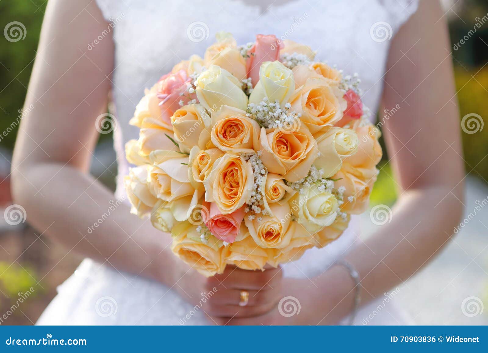 Braut mit rosafarbenem Blumenstrauß der Hochzeit draußen