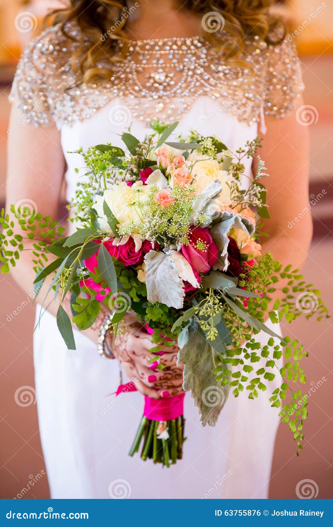 Brautholdingblumenstrauß der Blumen. Braut mit Hennastrauch tätowiert das Halten ihres Blumenstraußes der Blumen an ihrem Hochzeitstag