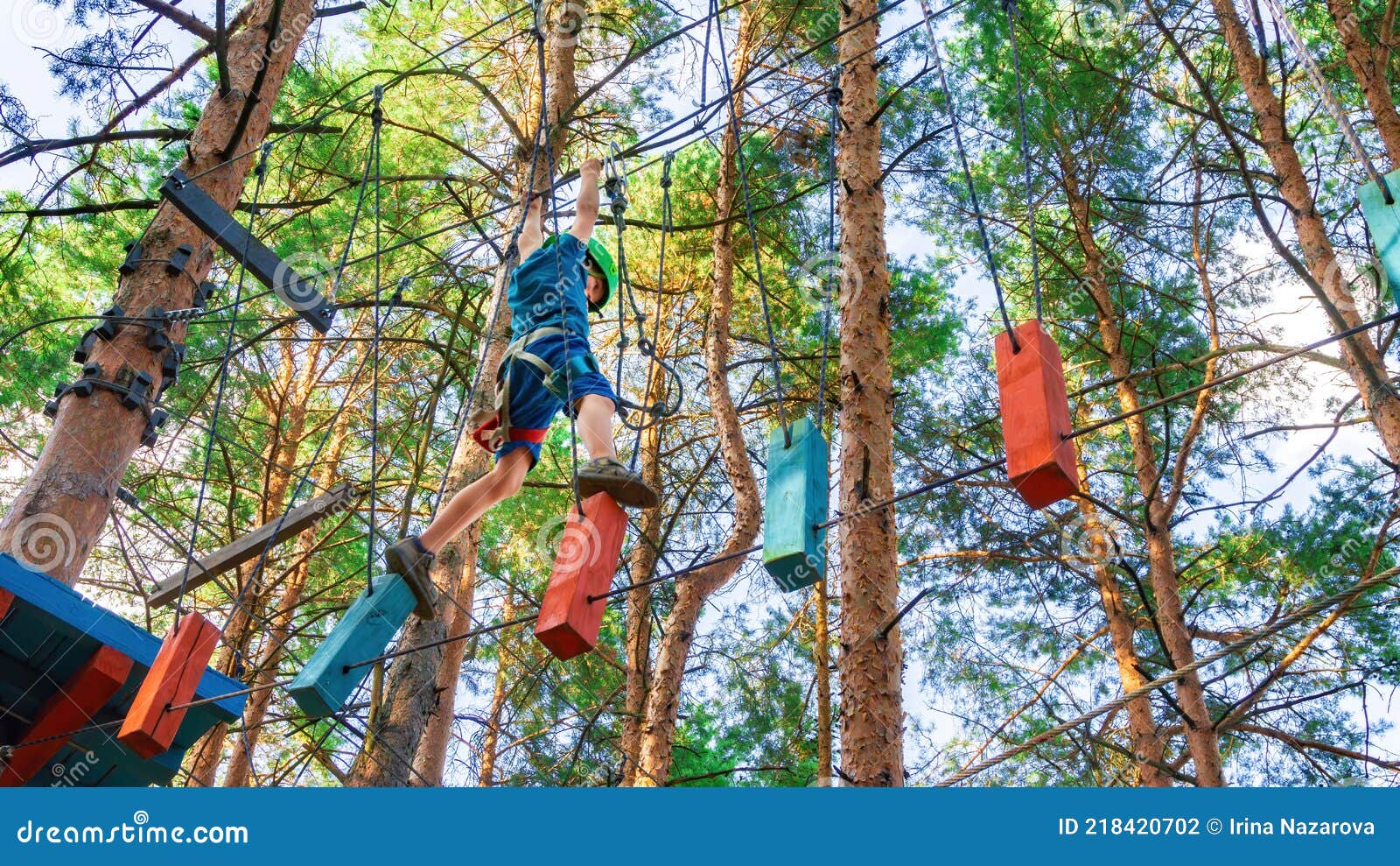 A Brave Boy Moves Along a Thin Rope Stretched between Trees in a