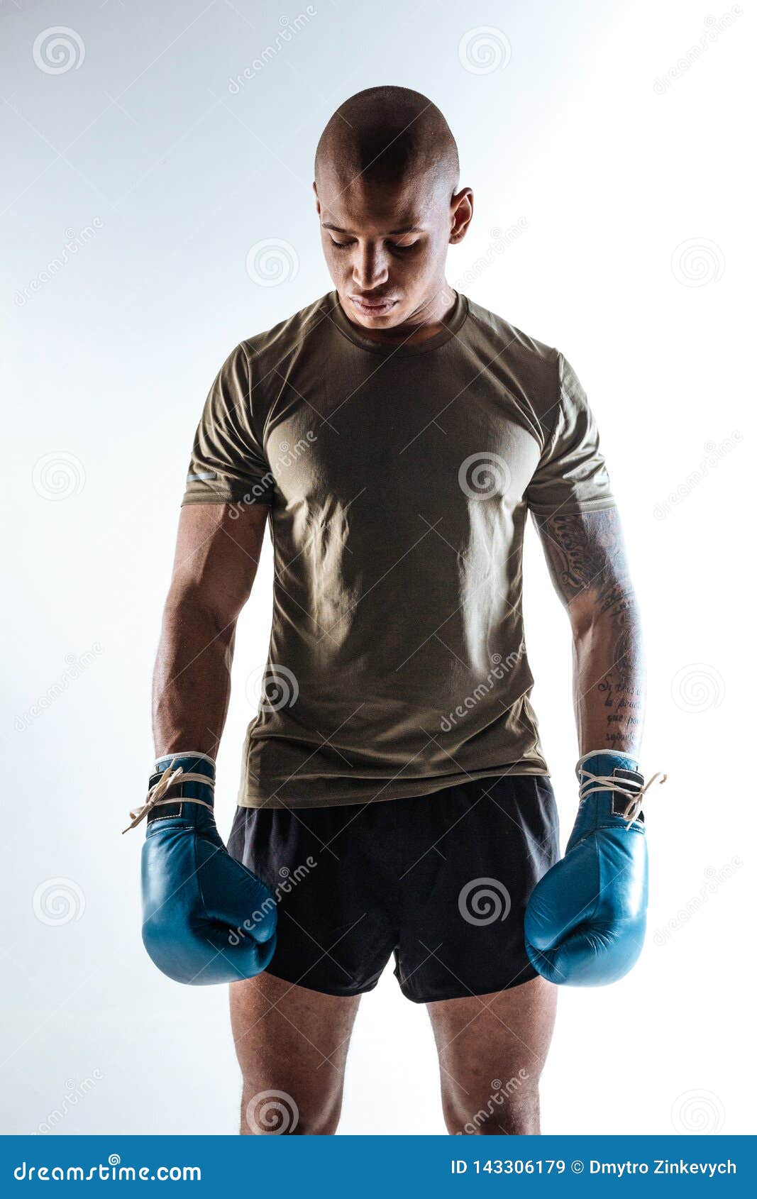 brawny sportive boxer wearing sport suit and boxing gloves