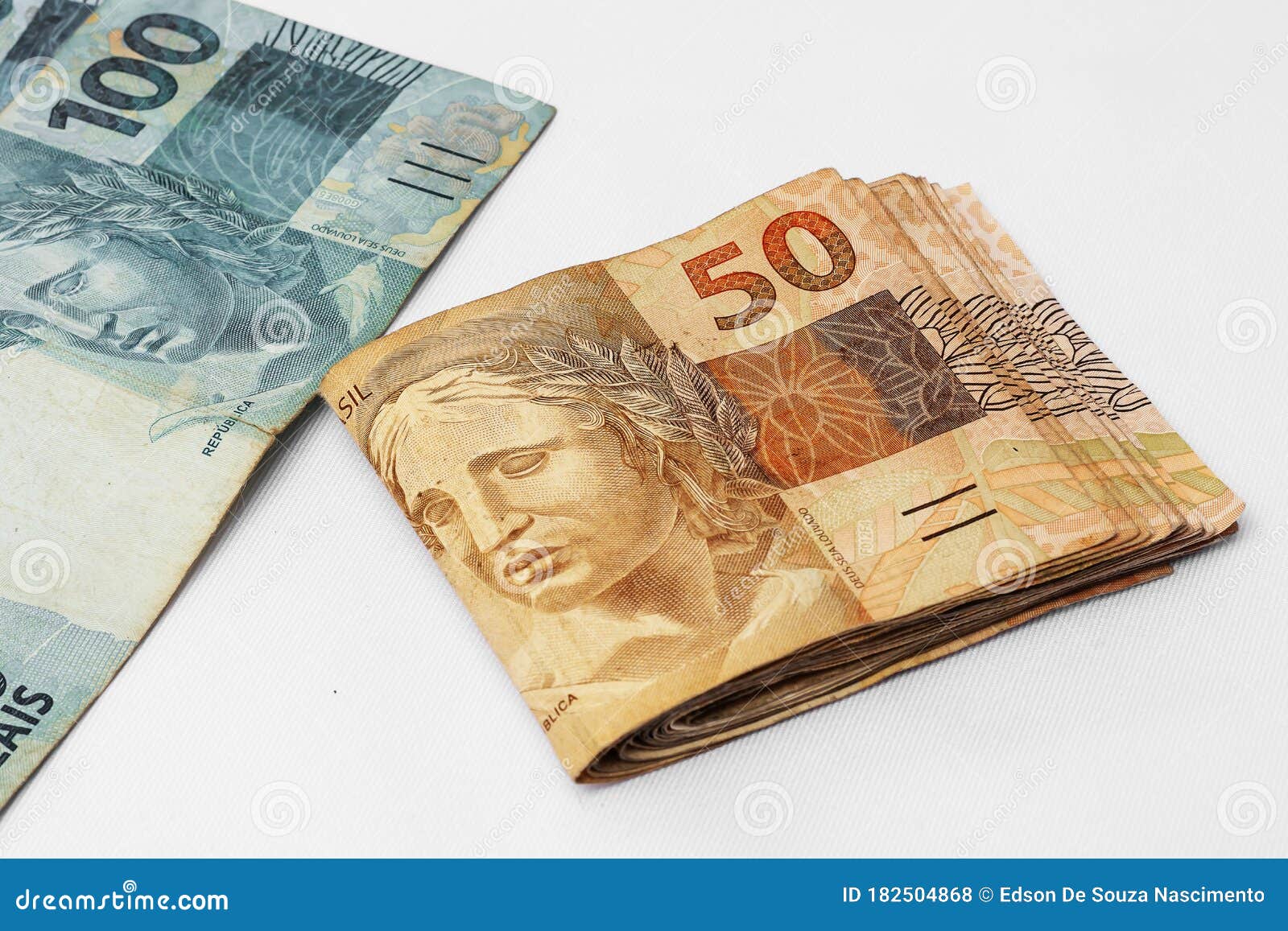 brazilian money scattered photographed on a white background