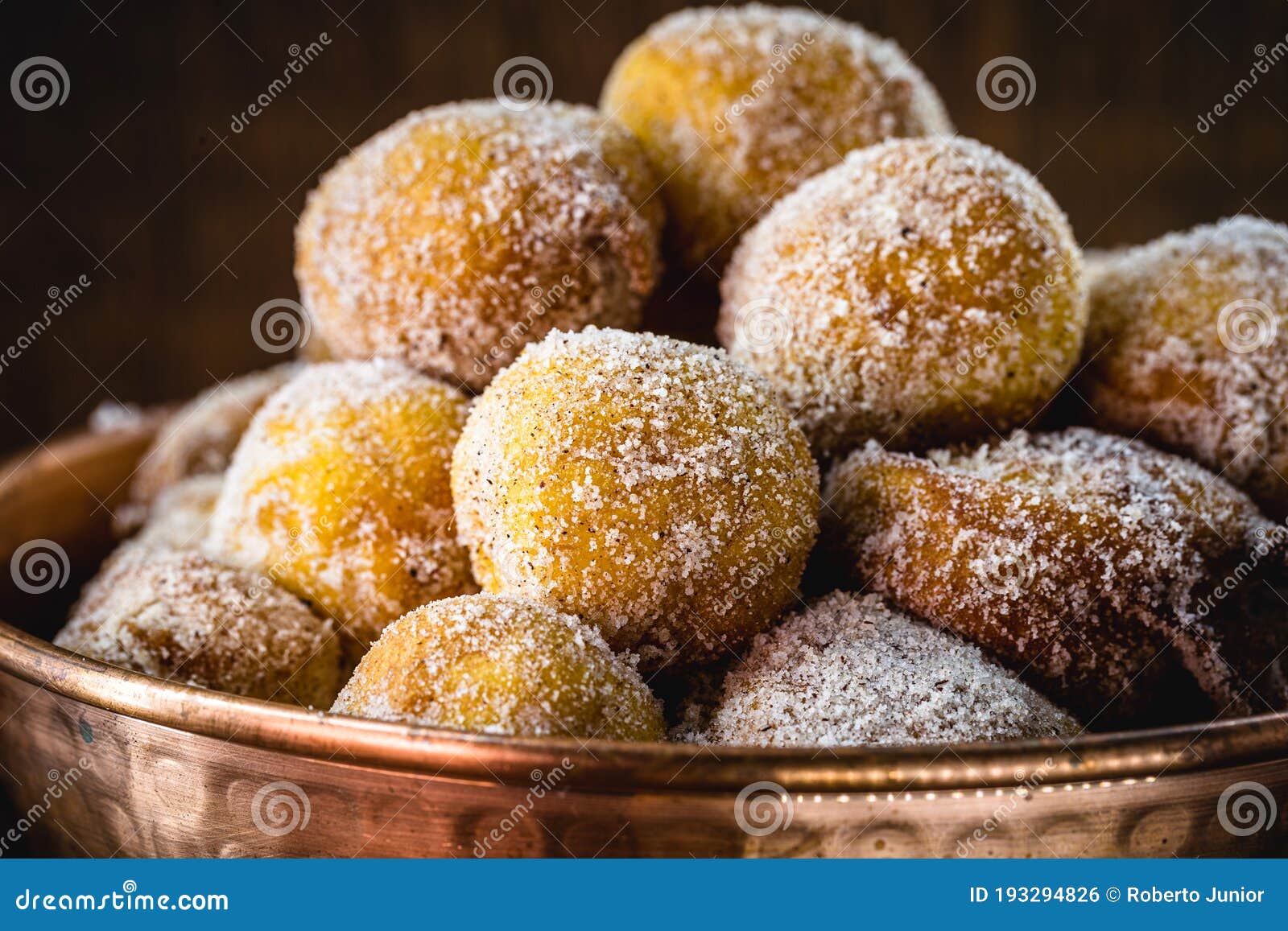 brazilian sweet called bolinho de chuva, made with cinnamon, refined and fried sugar. food served in a copper pot, typical sweet