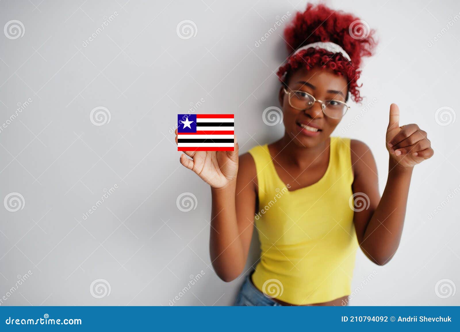 brazilian woman with afro hair hold maranhao flag  on white background, show thumb up. states of brazil concept