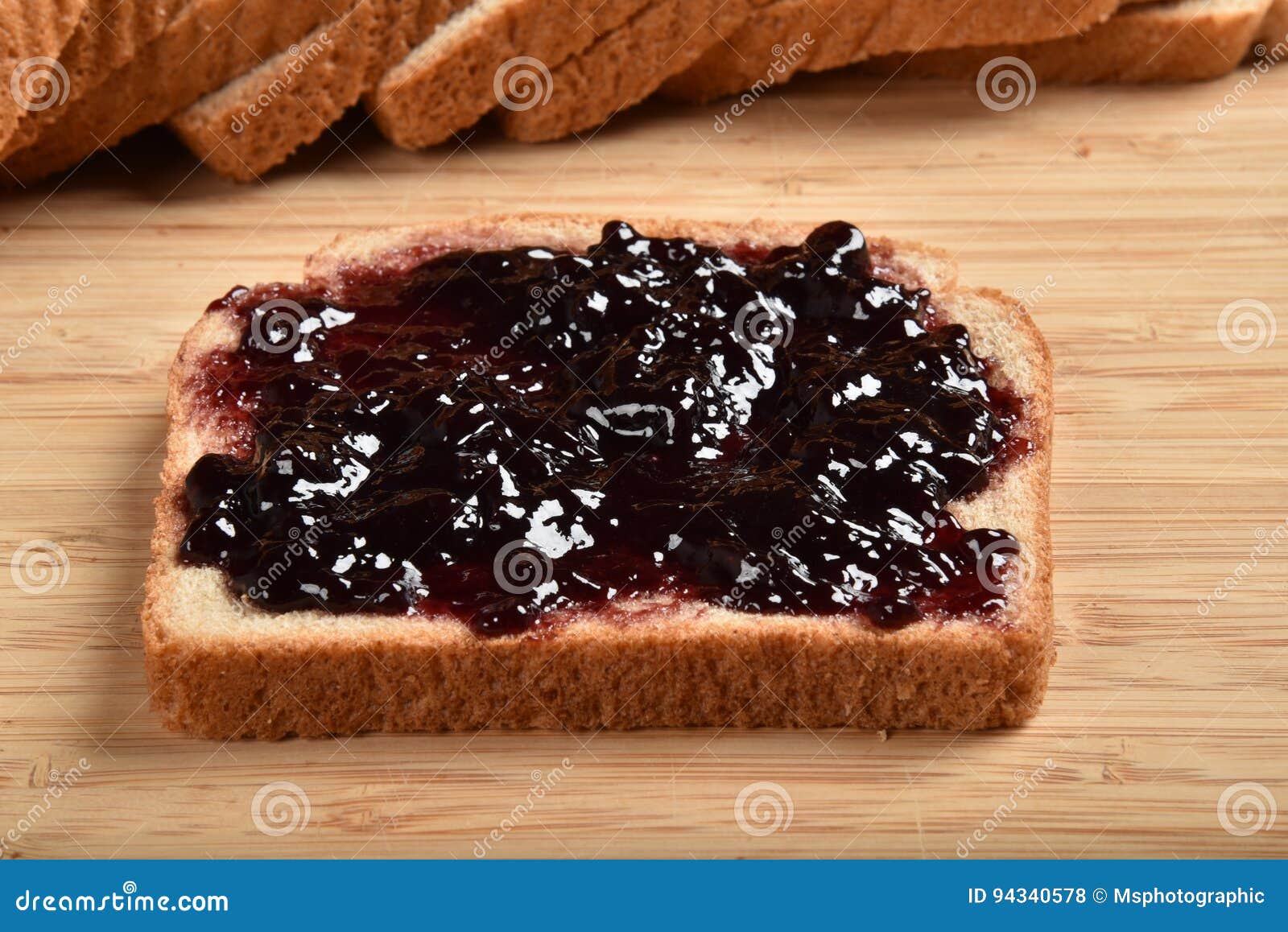 spreading grape jelly on bread