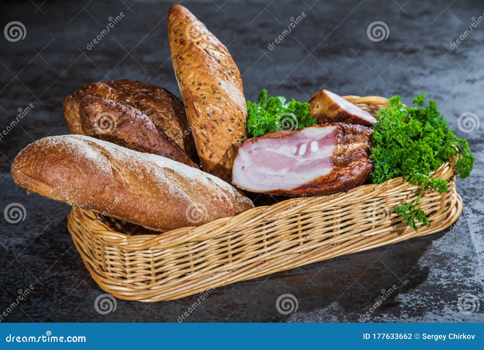 Bread and Smoked Meat in a Braided Basket on the Table. Stock Photo