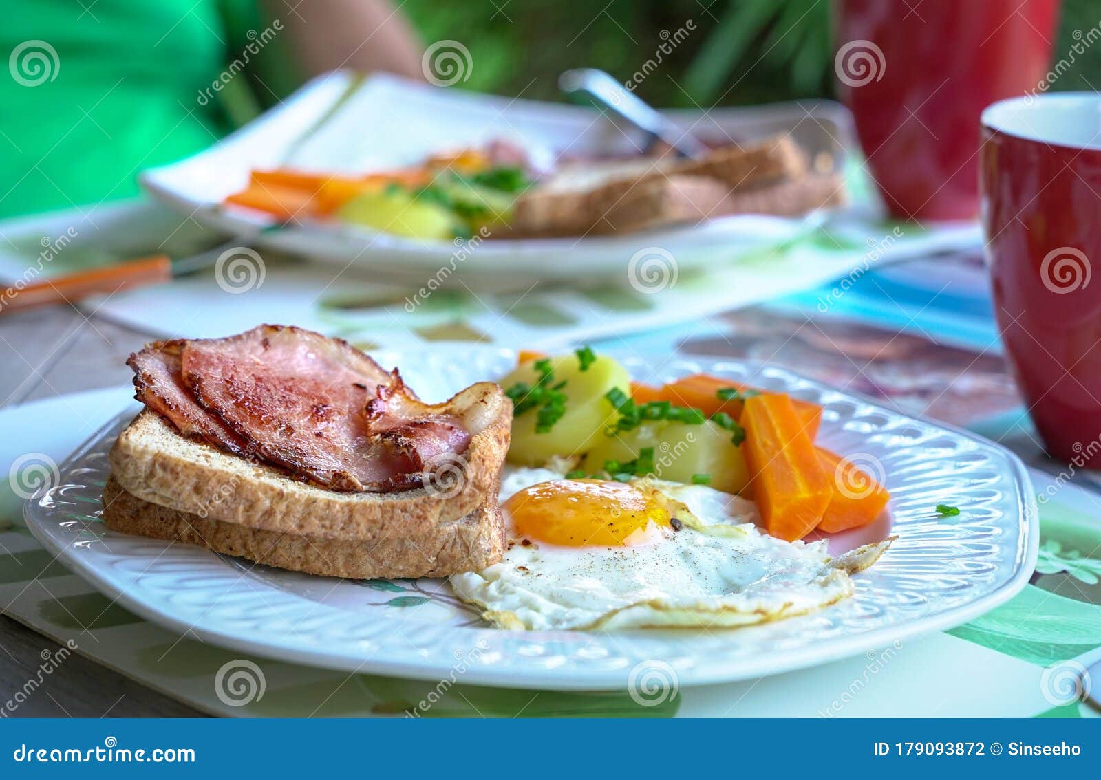 Breakfast with Bacon, Egg, Potatoes, Carrots and Bread Stock Photo