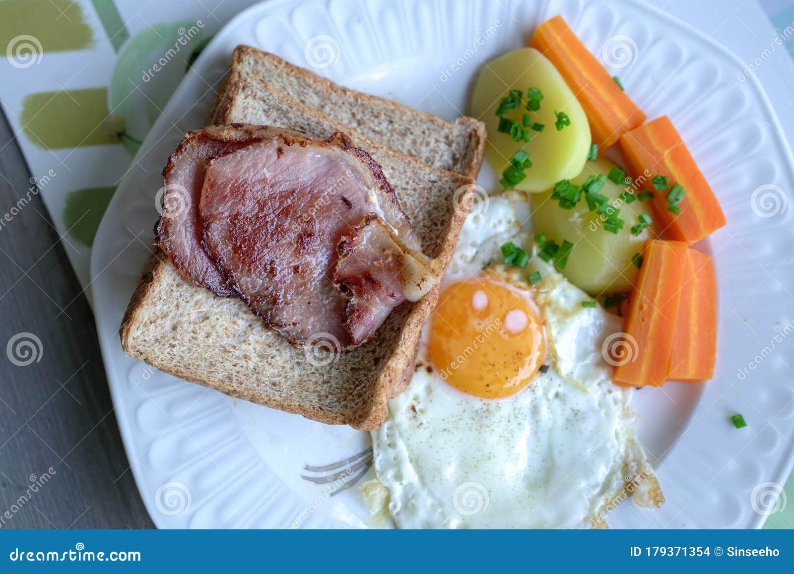 Breakfast with Bacon, Egg, Potatoes, Carrots and Bread Stock Photo