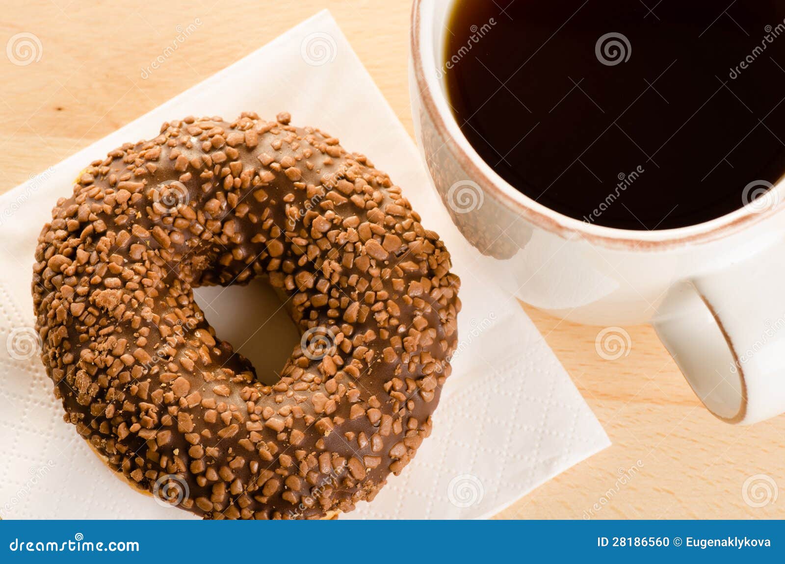 Breakfast of Coffee and Chocolate Glazed Donut on Table Stock Photo