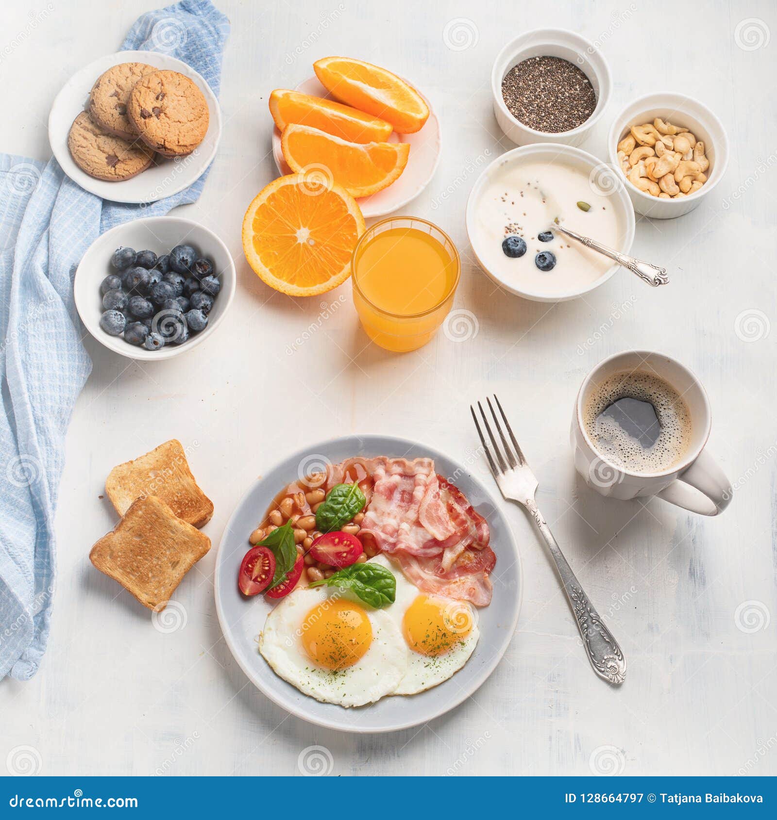 Breakfast with Fried Eggs, Bacon, Orange Juice, Yogurt and Toast Stock