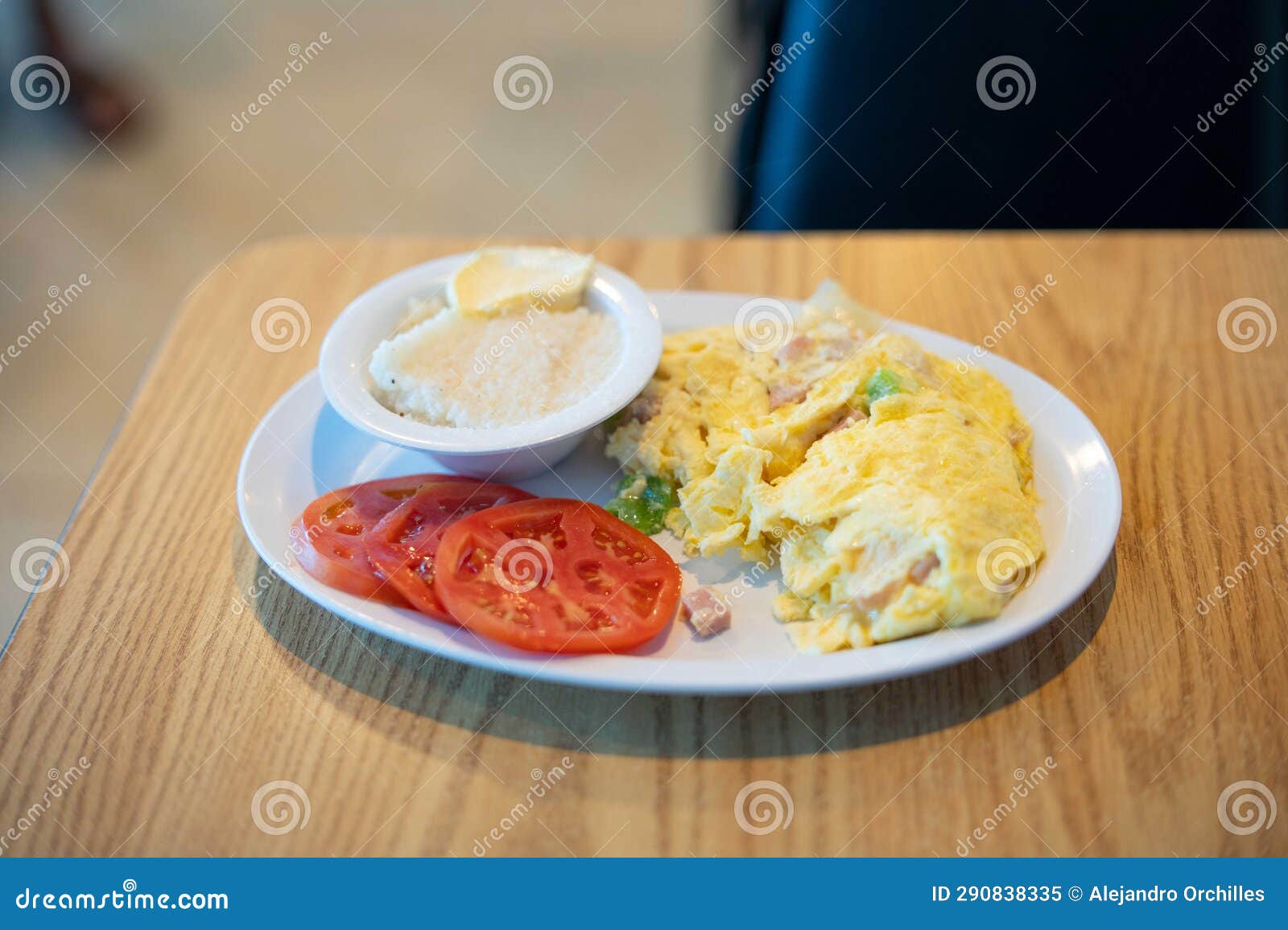 Breakfast Platter with Grits Tomatoes and Scrambled Eggs with Ham and