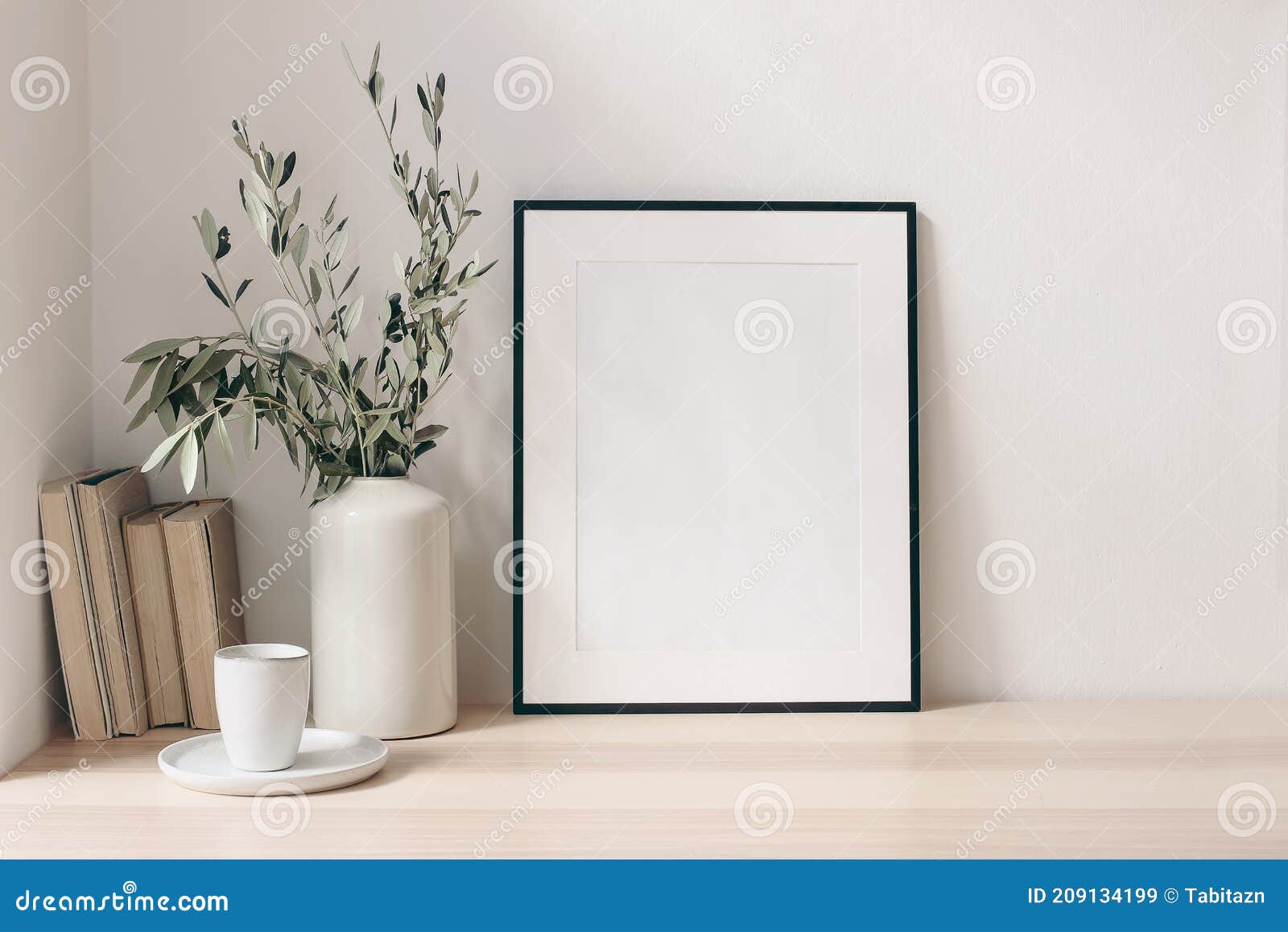 breakfast still life. cup of coffee, books and empty picture frame mockup on wooden desk, table. vase with olive