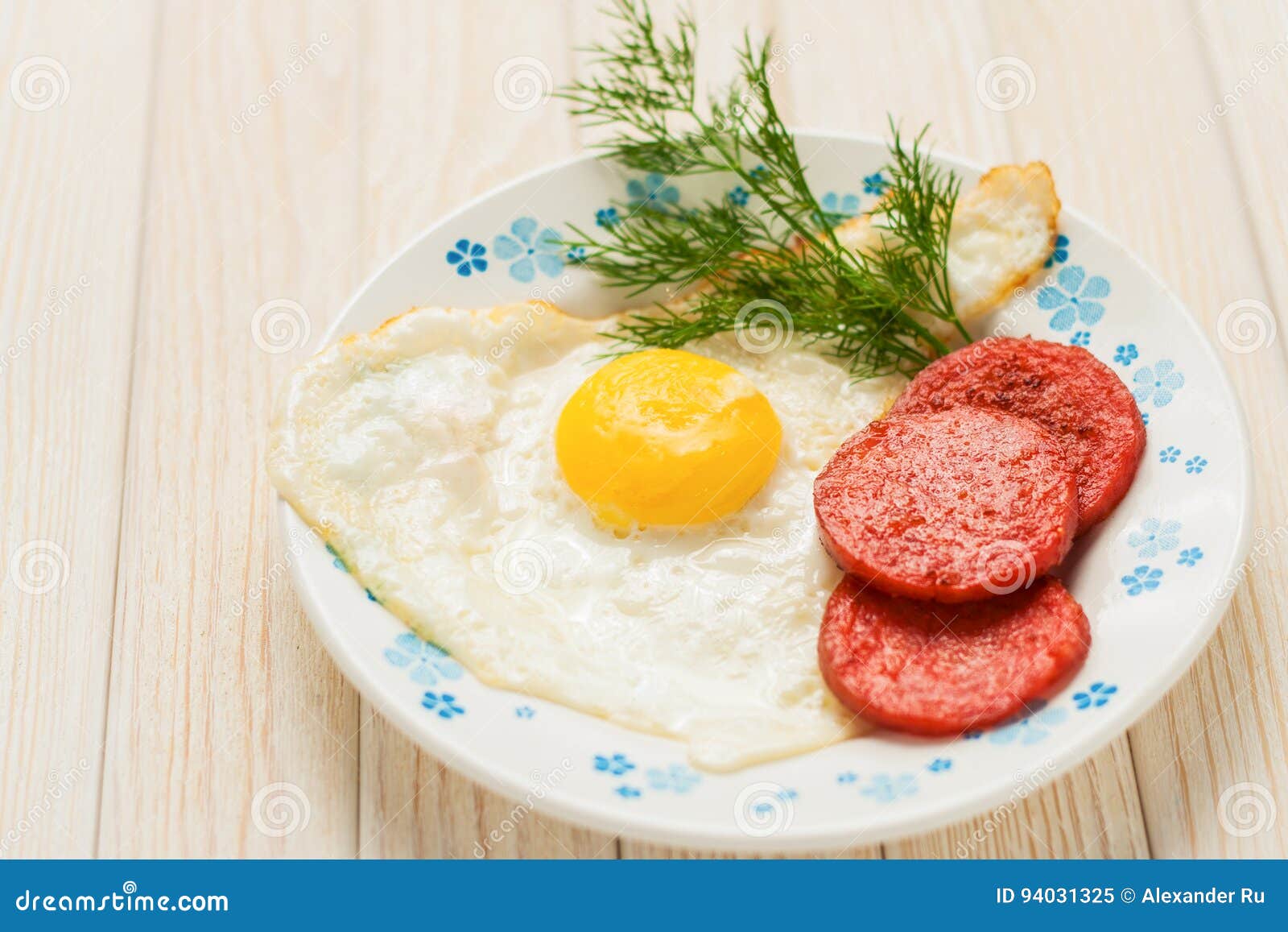 Breakfast on the Table. Fried Eggs with Fried Sausages Salami and Dill