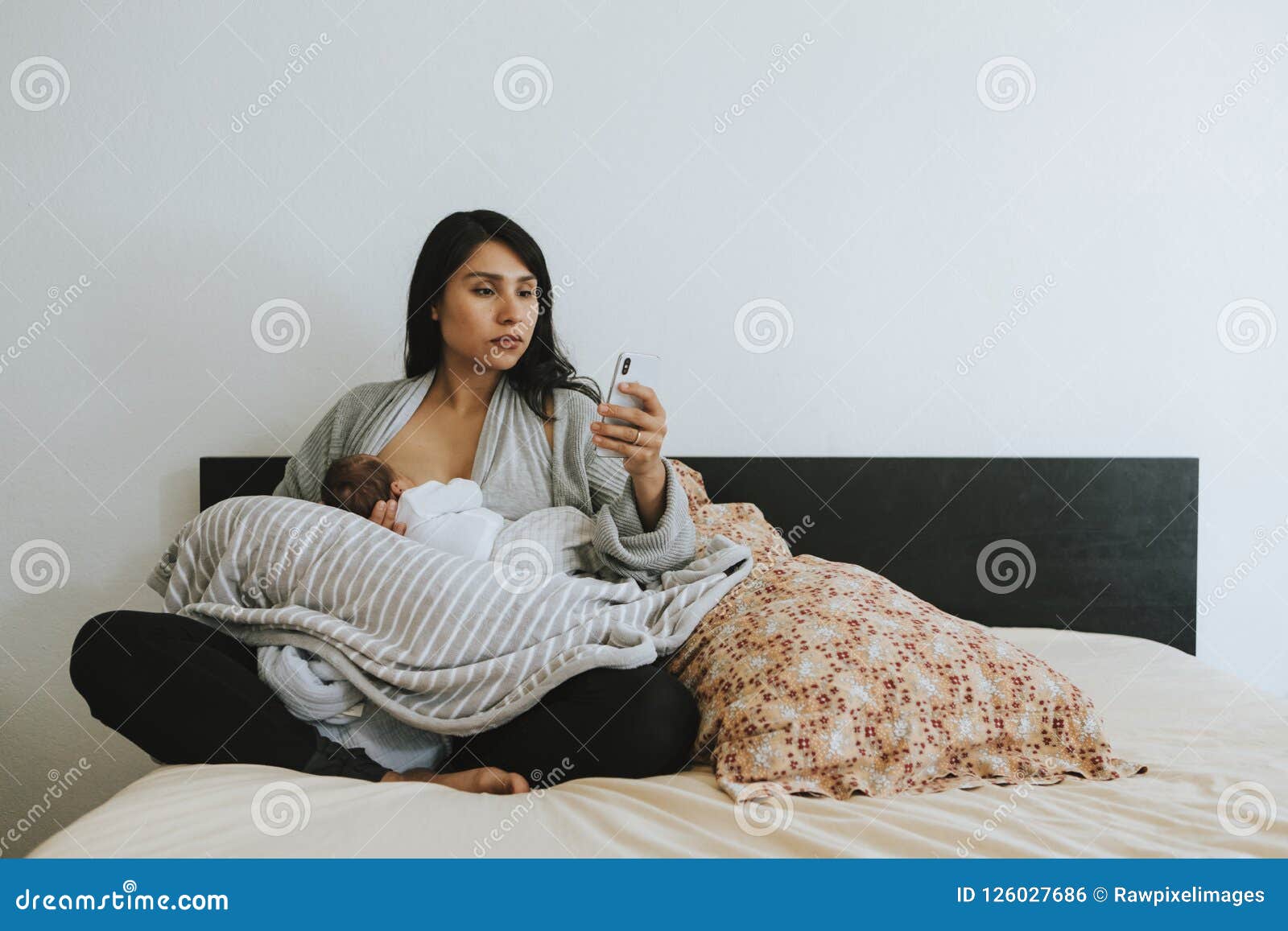 Breastfeeding Mother Using a Smartphone Stock Photo Image of