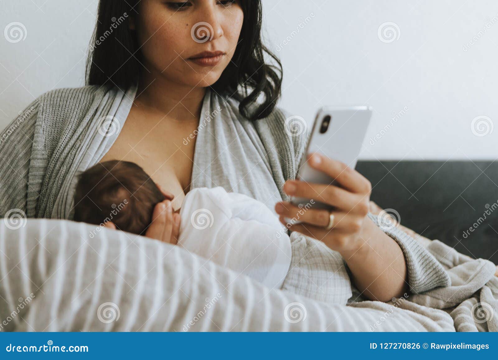 Breastfeeding Mother Using a Smartphone Stock Photo Image of bond
