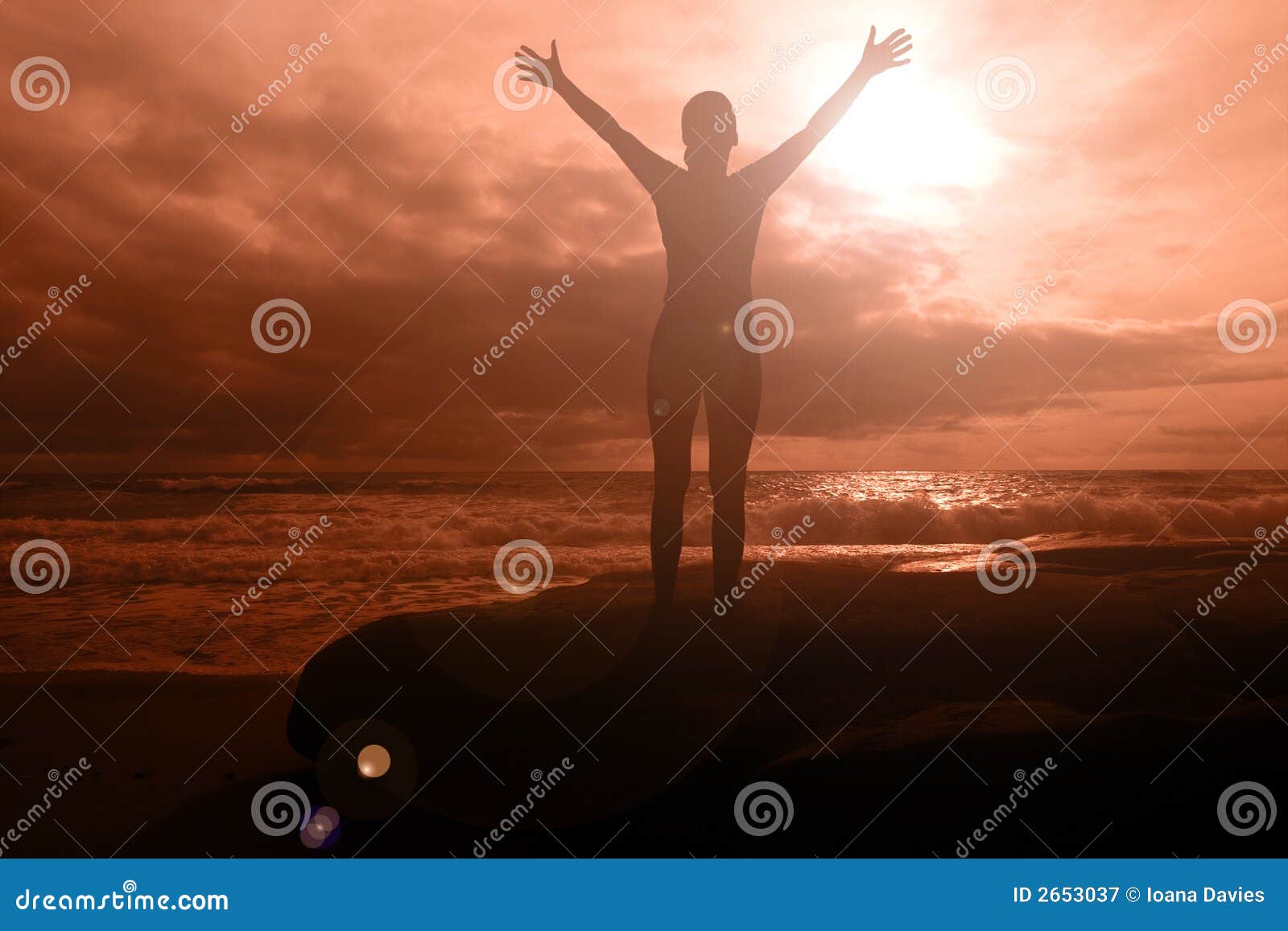 Brennender Ruhm - Frau mit den Armen hob auf einen brennenden Sonnenuntergangmeerblick mit drastischen Wolken an