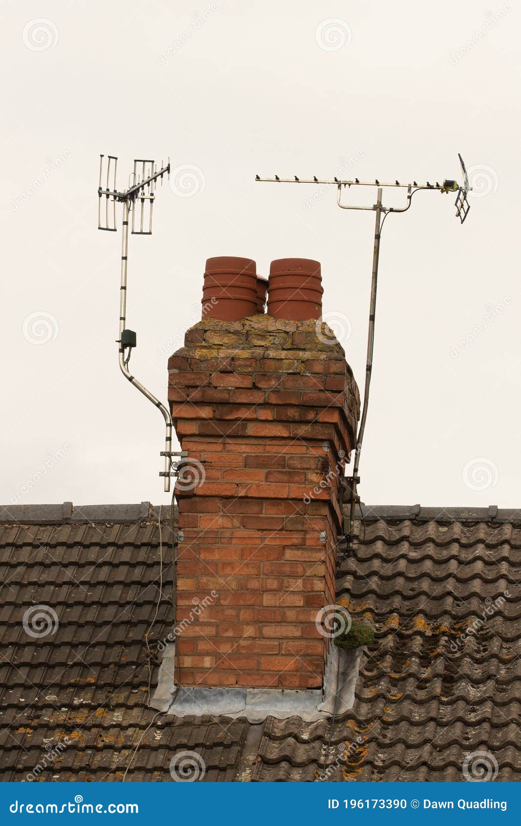 brick chimney stack and tv aerials on english rooftop