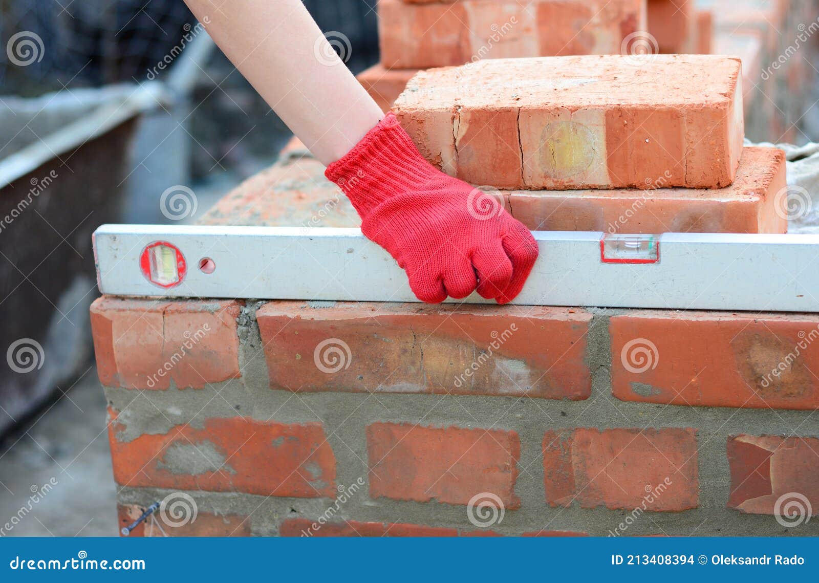 Brick Masonry a Bricklayer is Checking the Evenness of a Brick Wall