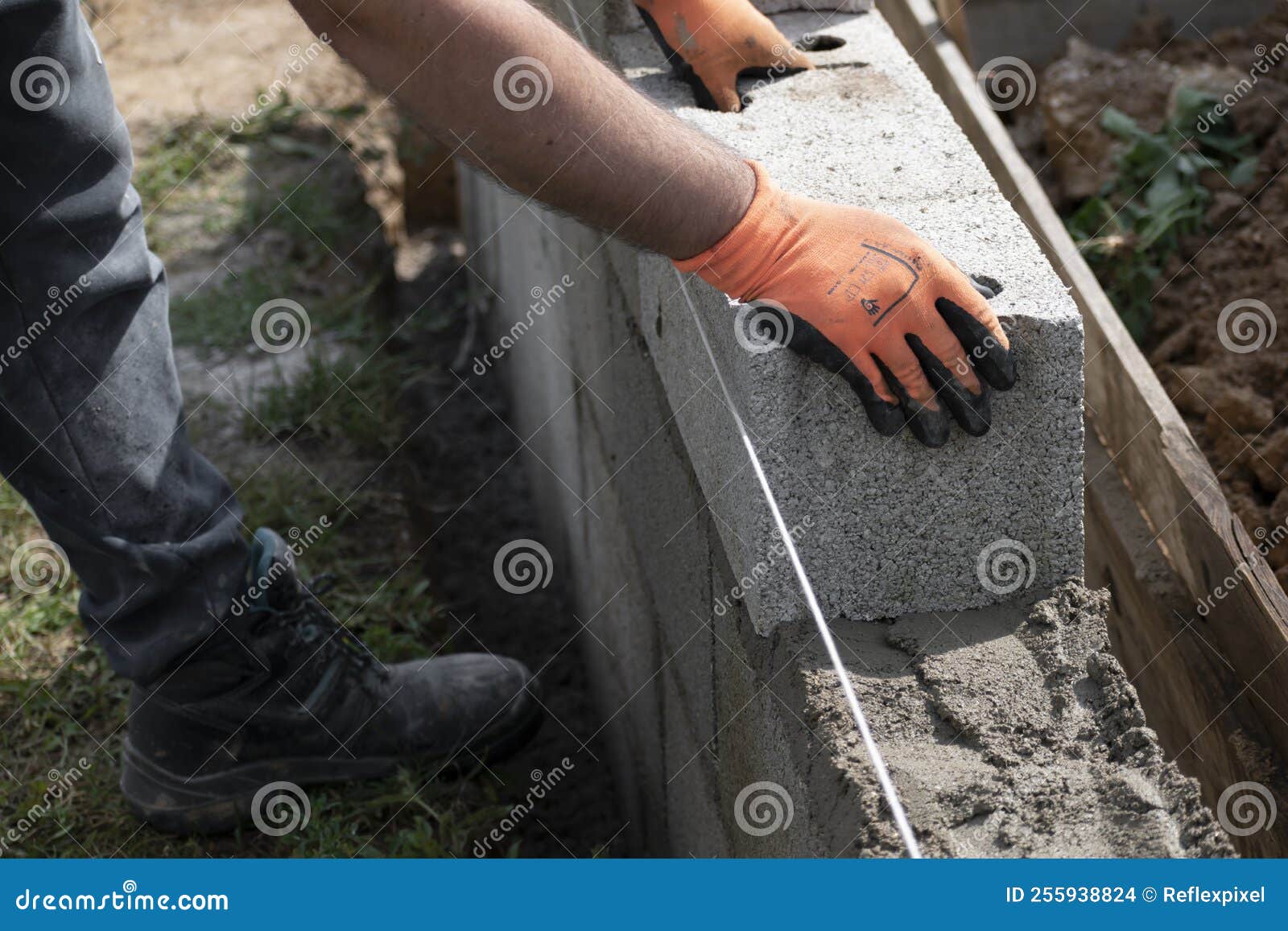 Bricklayer in Glove Spreading Concrete To Build a Wall on Construction