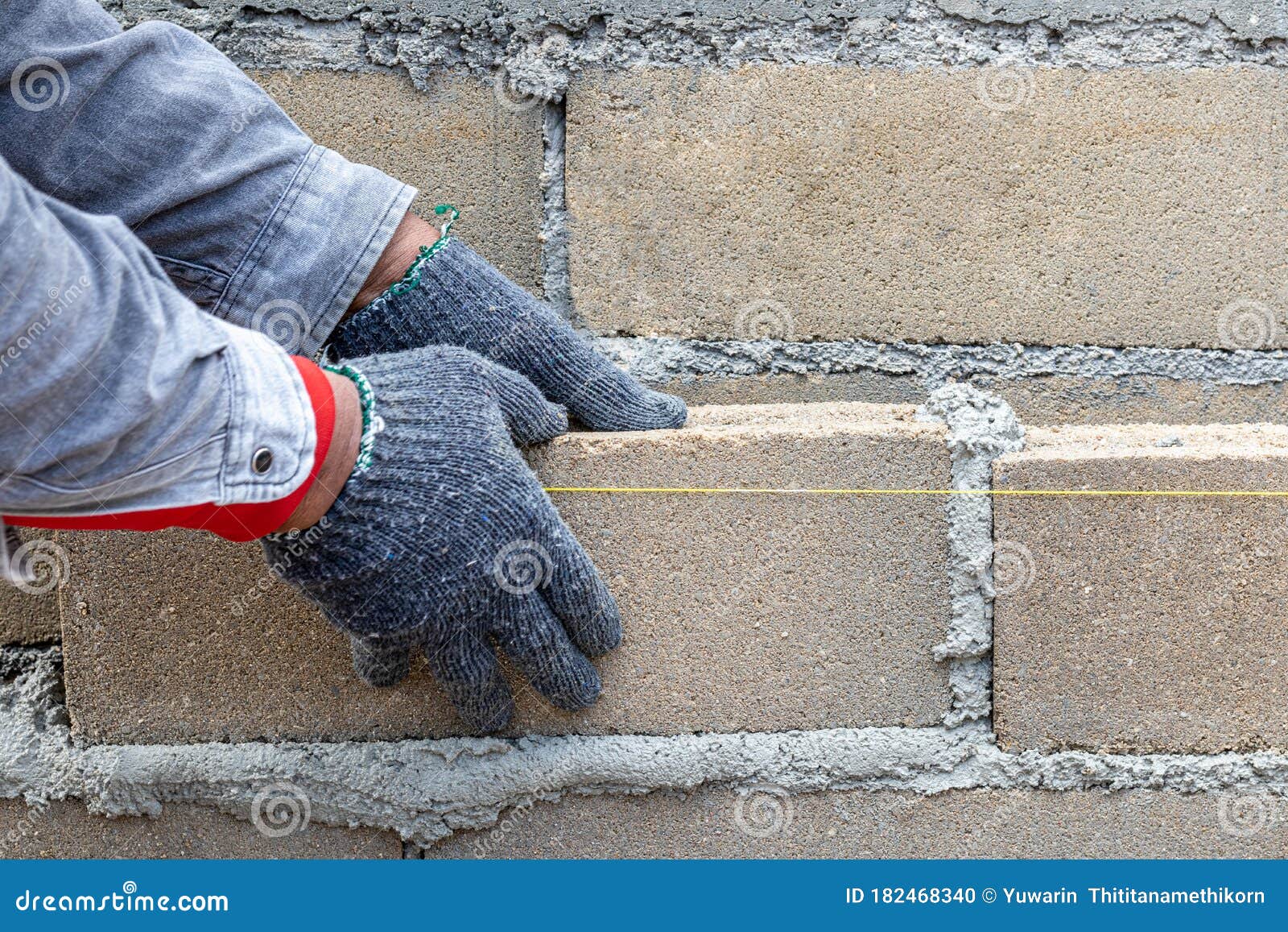Bricklayer Worker Installing Bricks on Construction Site. the Hands of