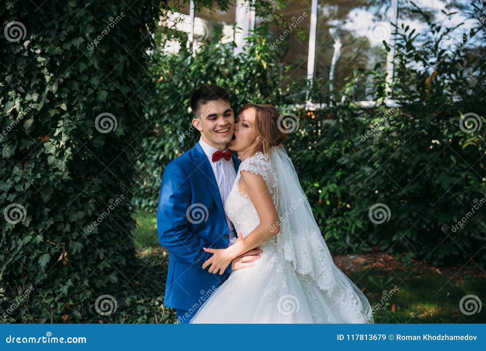 bride beautiful white dress jokes bites groom cheek guy will sweep newlyweds happy their wedding day 117813679