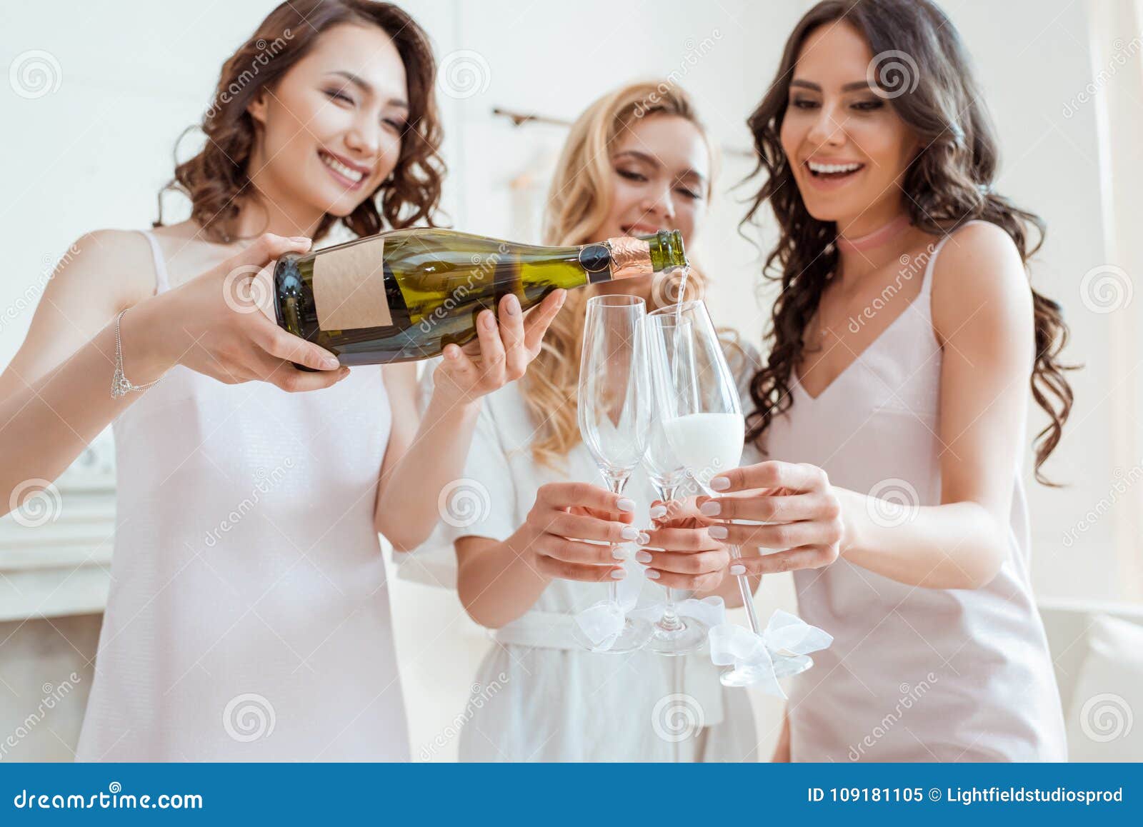 bride with bridesmaids pouring champagne in glasses