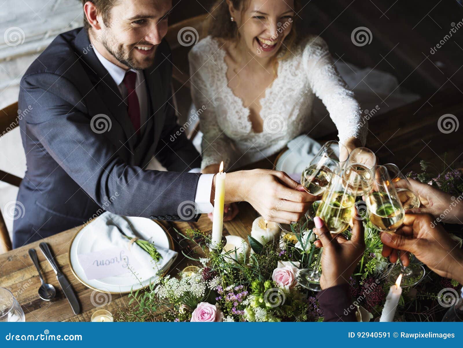 bride and groom clinging wineglasses with friends on reception
