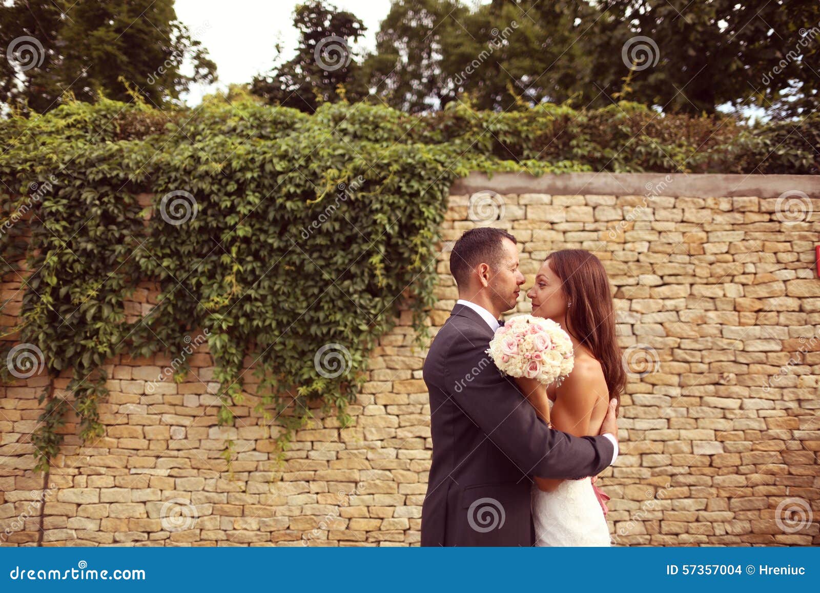 Bride and groom outdoors on their wedding day. Bride and groom hugging each other