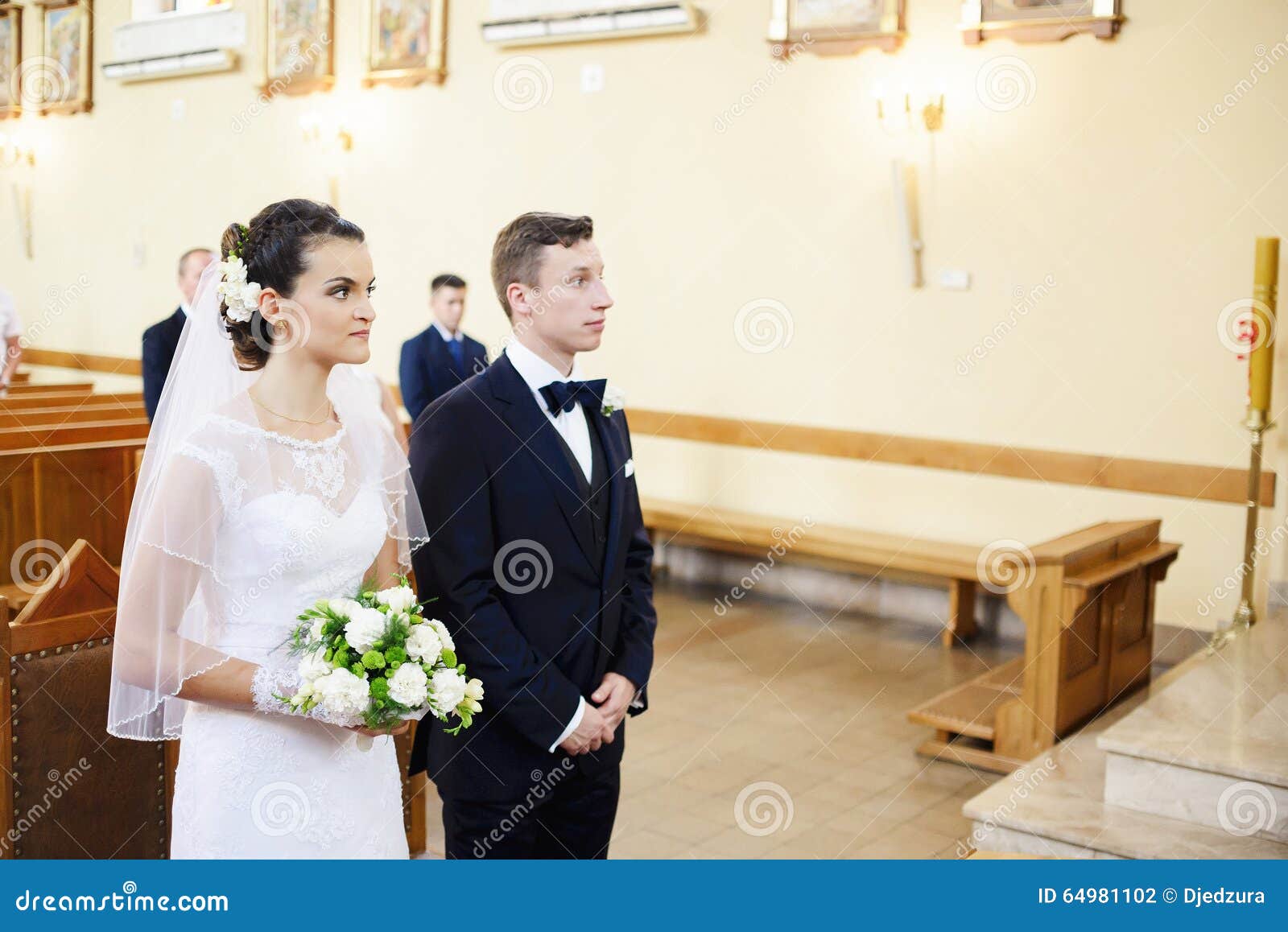 The Bride And Groom Standing At The Altar In The Church Stock