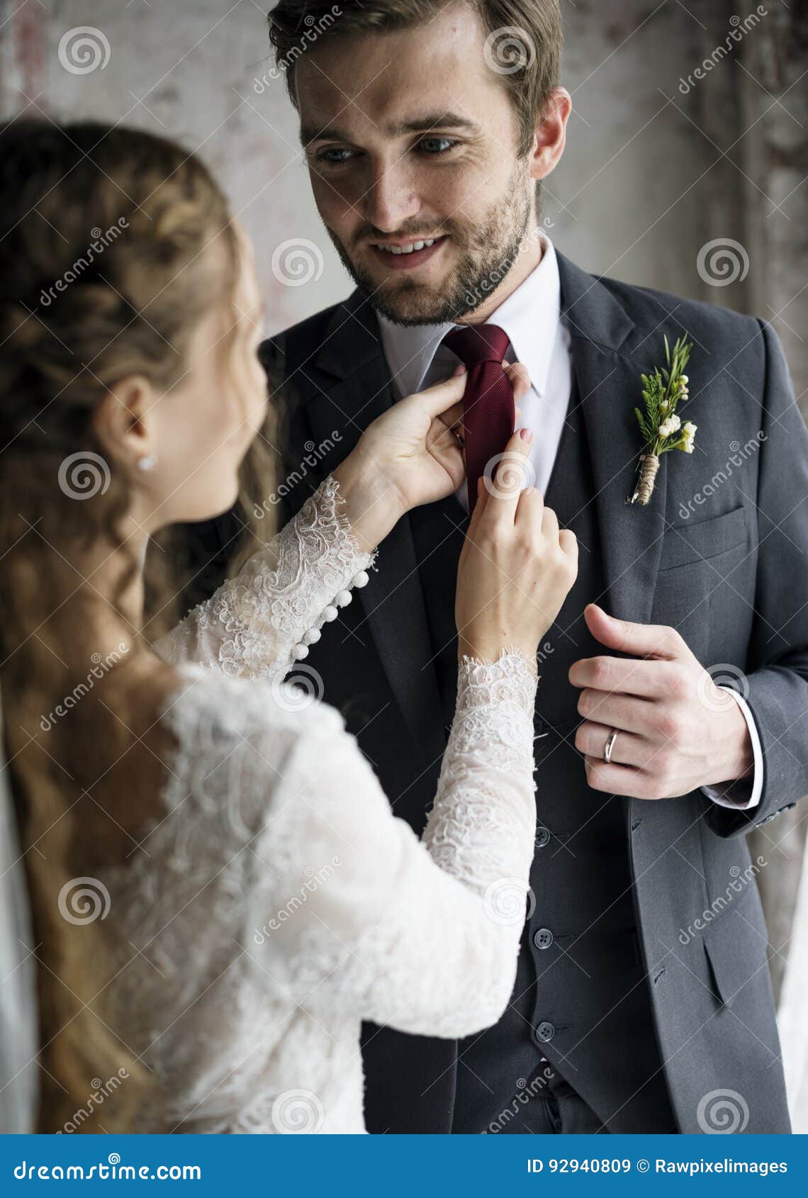 Bride Helping Groom Dressing Up for Wedding Ceremony Stock Image