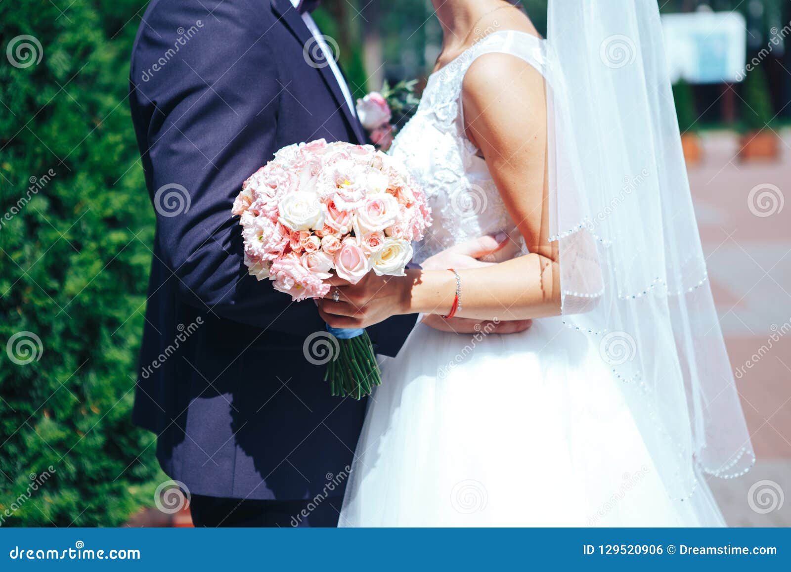 Bride Holds a Wedding Bouquet in Hands, the Groom Hugs His Bride ...