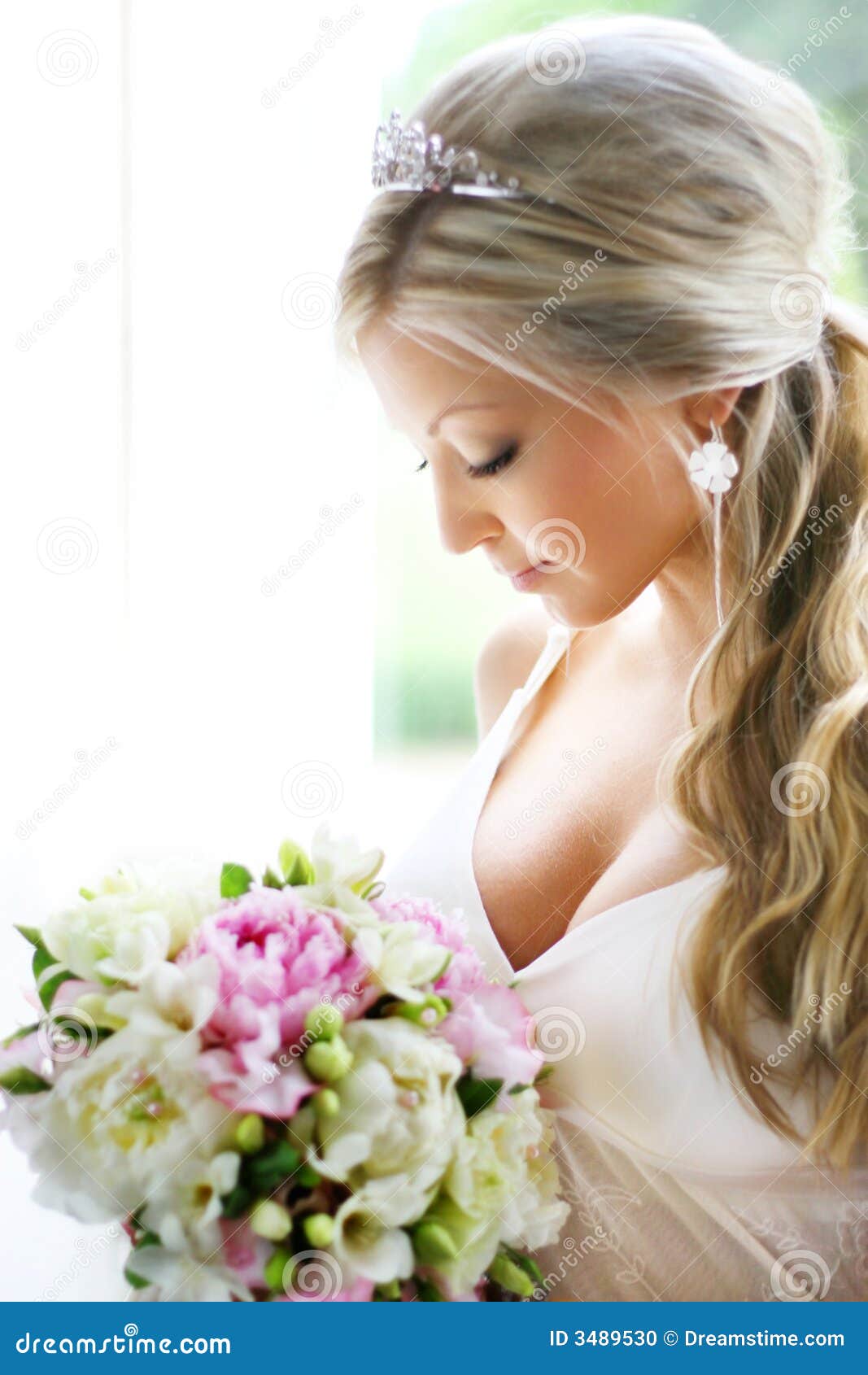 Bride looking at bouquet stock photo. Image of gazing 