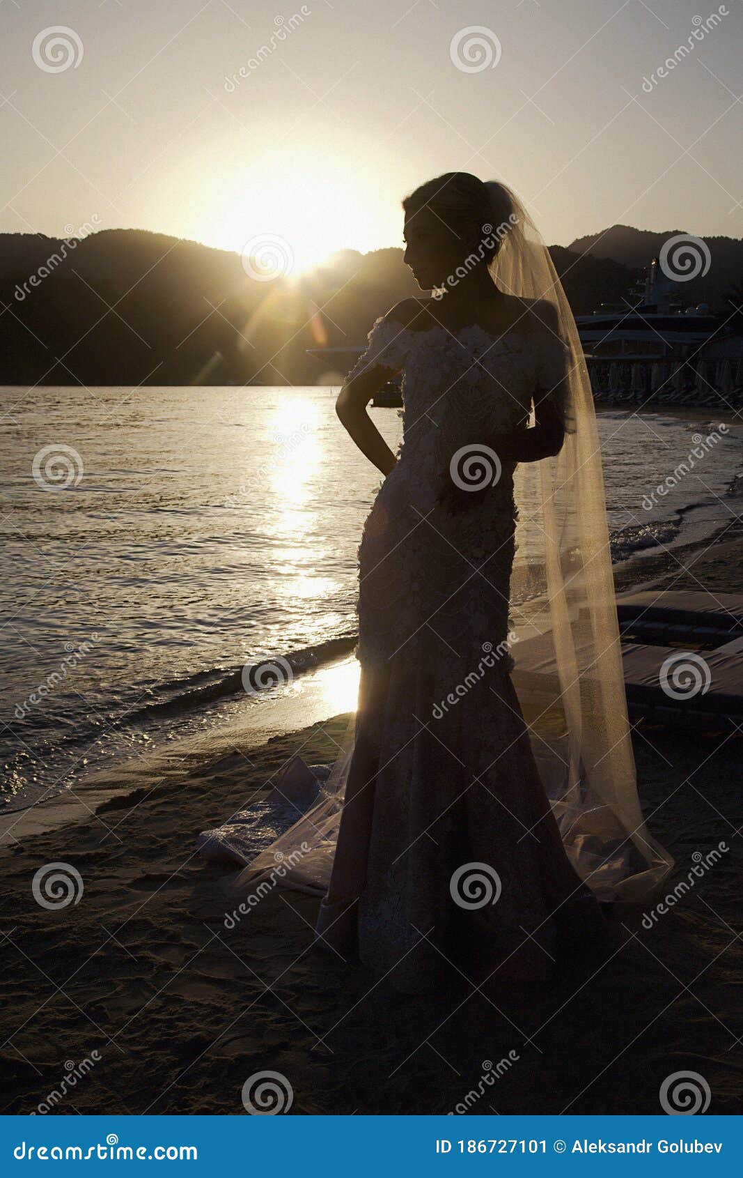 bride on ocean or sea at sunset on wedding day