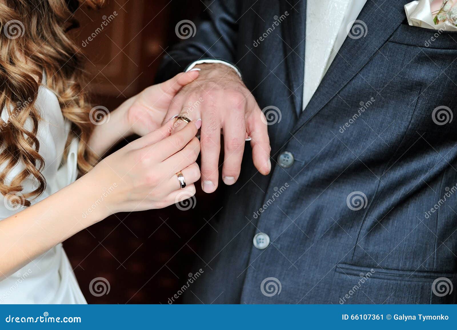 Bride Puts Wedding Ring on Groom Finger on Day of the Wedding Ceremony