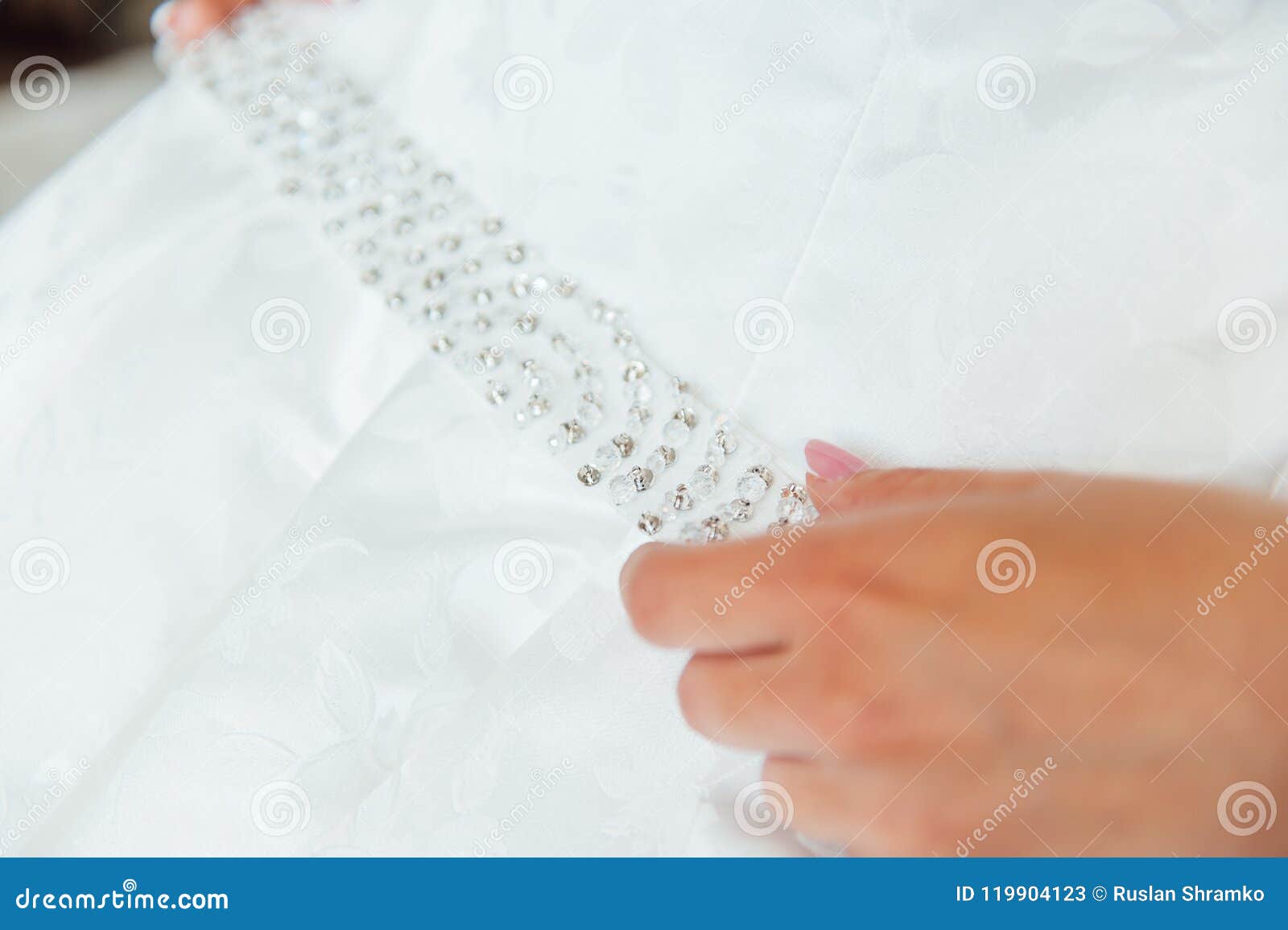 Bride Putting on the Wedding Dress with a Decorated Belt Stock Image