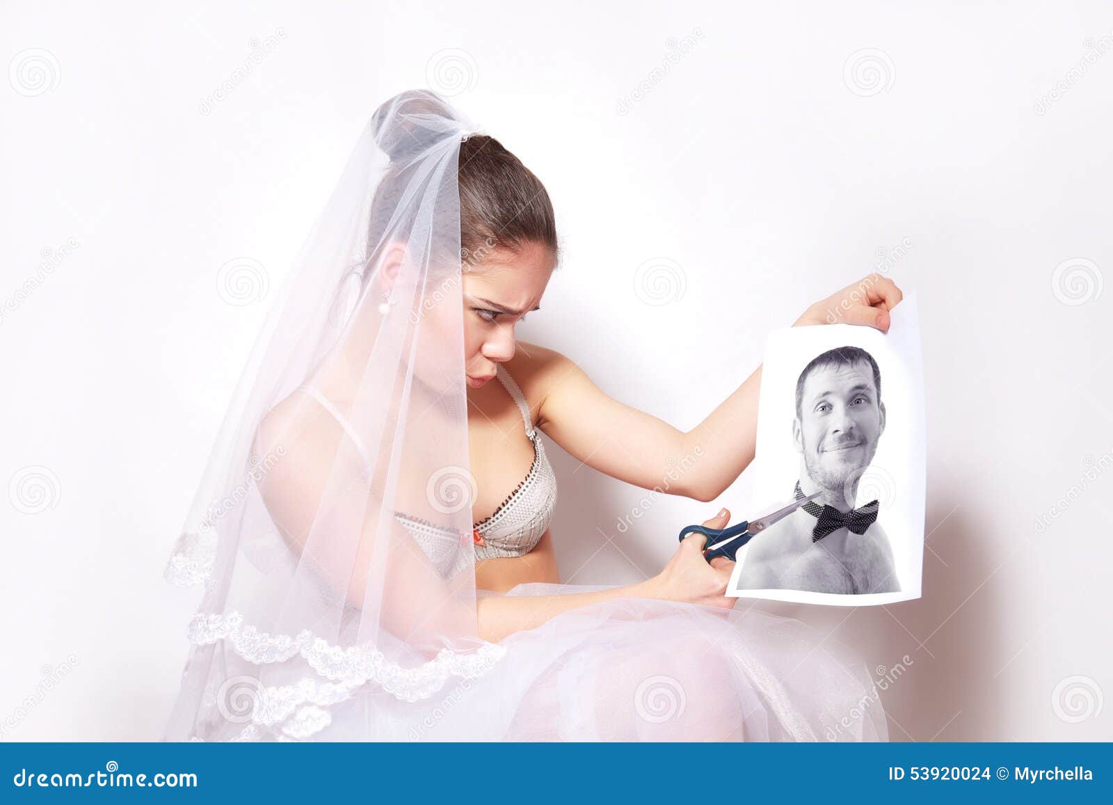 Bride scissor a photo which shows the groom. Bride scissor the photo which shows the groom, gray background