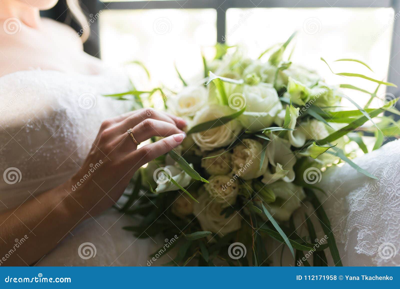 Bride Touching Wedding Bouquet with One Hand with Wedding Ring on Her ...