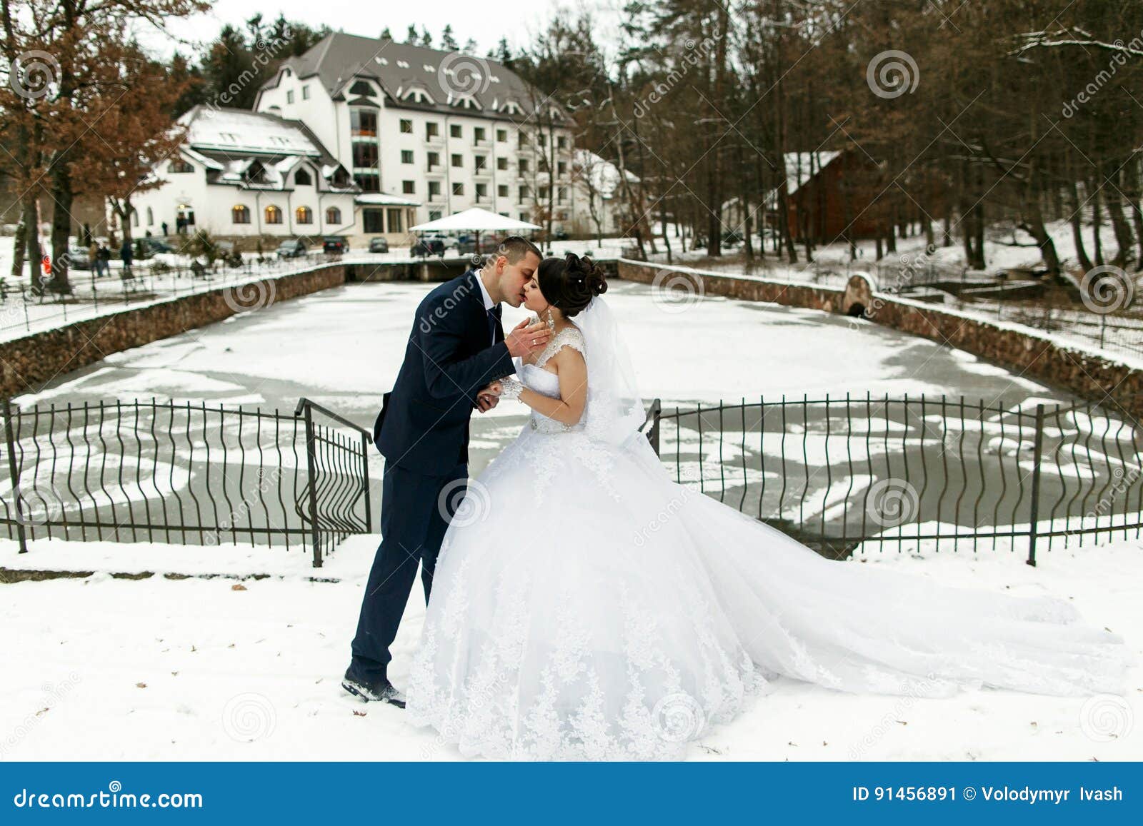 the brides kissing near frozen lake