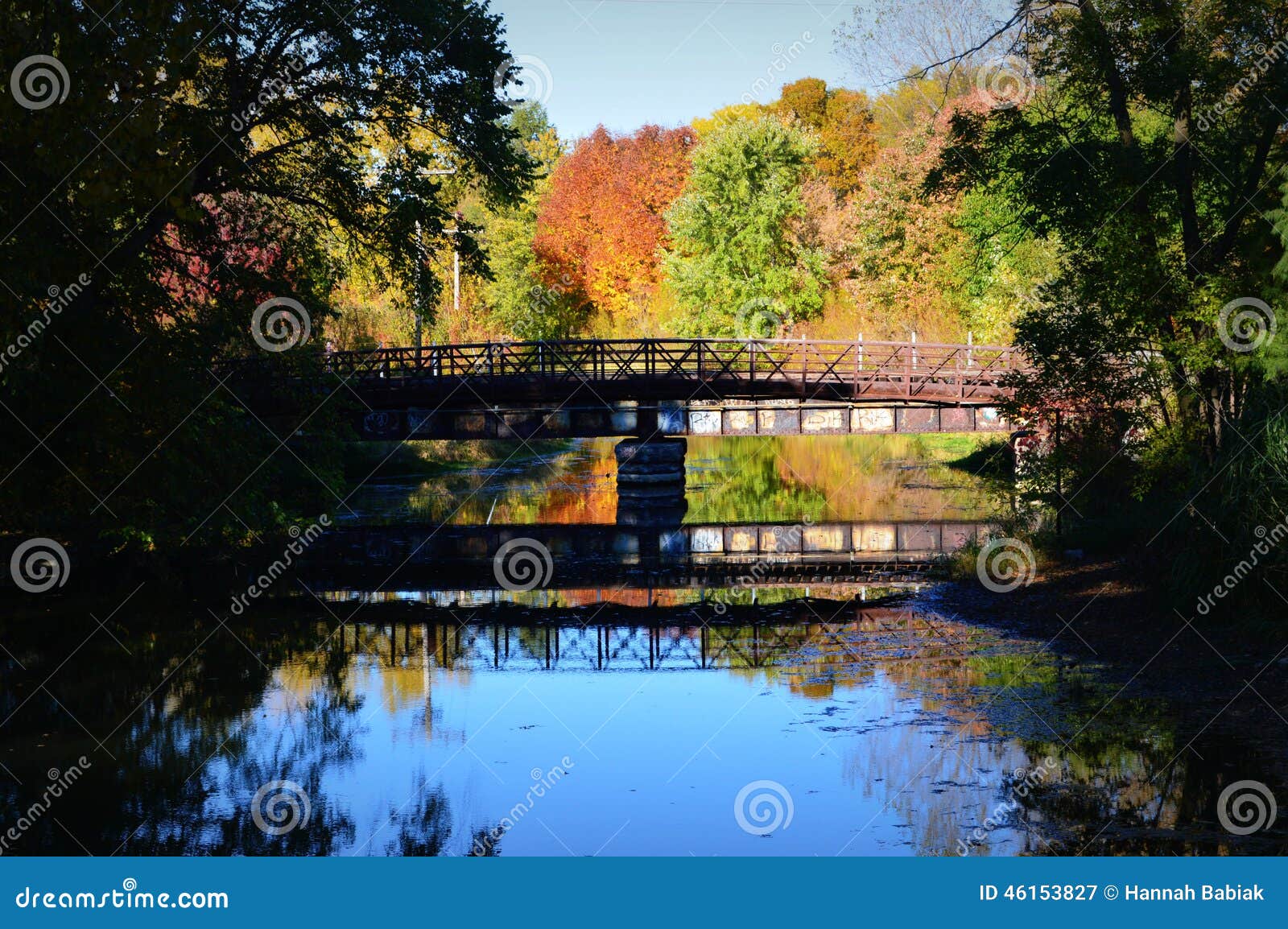 Bridge, Reflection, Fall Colors. A bridge and it s reflection in the Yahara river with some beautiful fall foliage behind it at the Olbrich Botanical Gardens in Madison, WI.