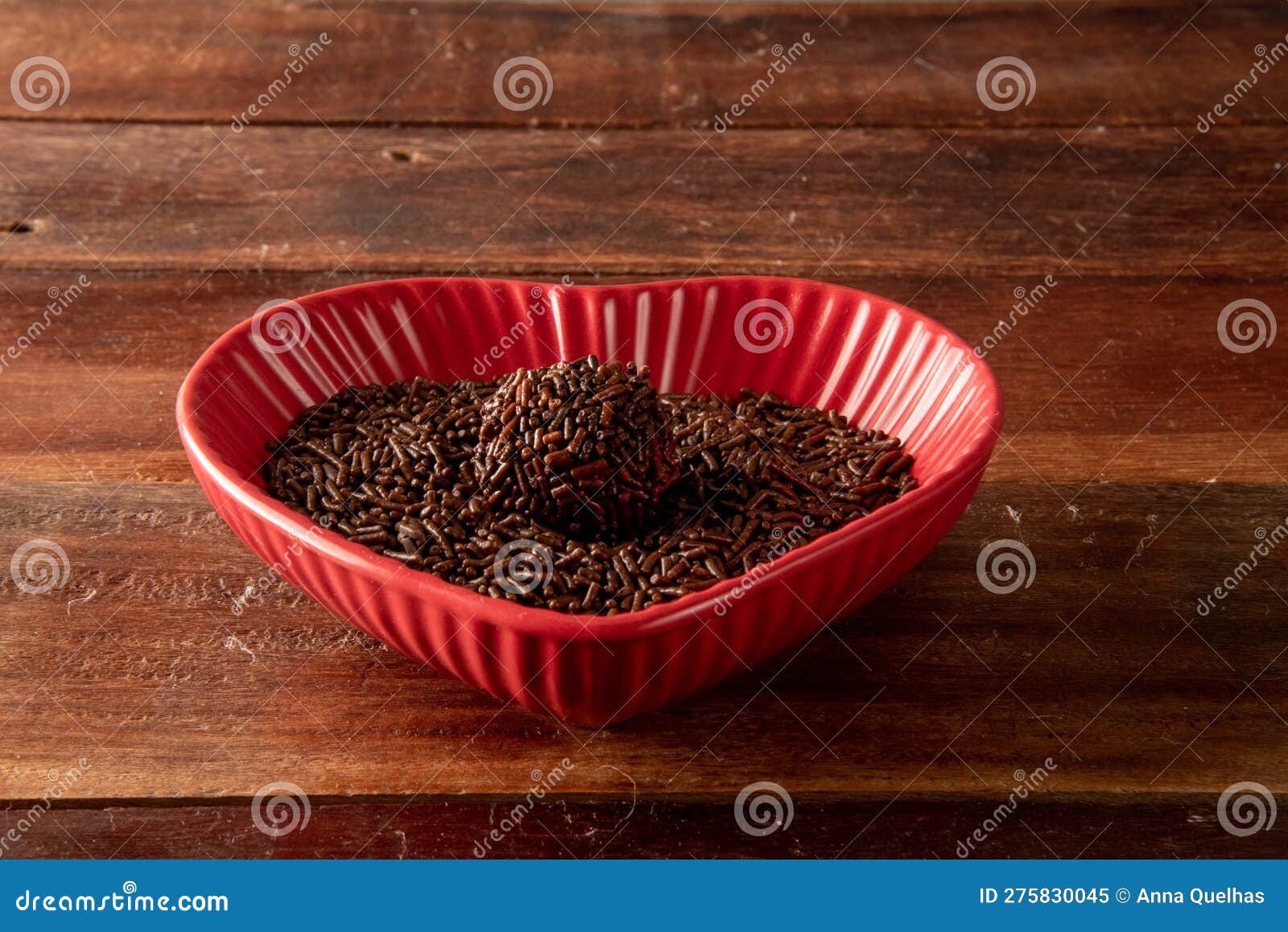 brigadeiro over a red heart d bowl and wooden background