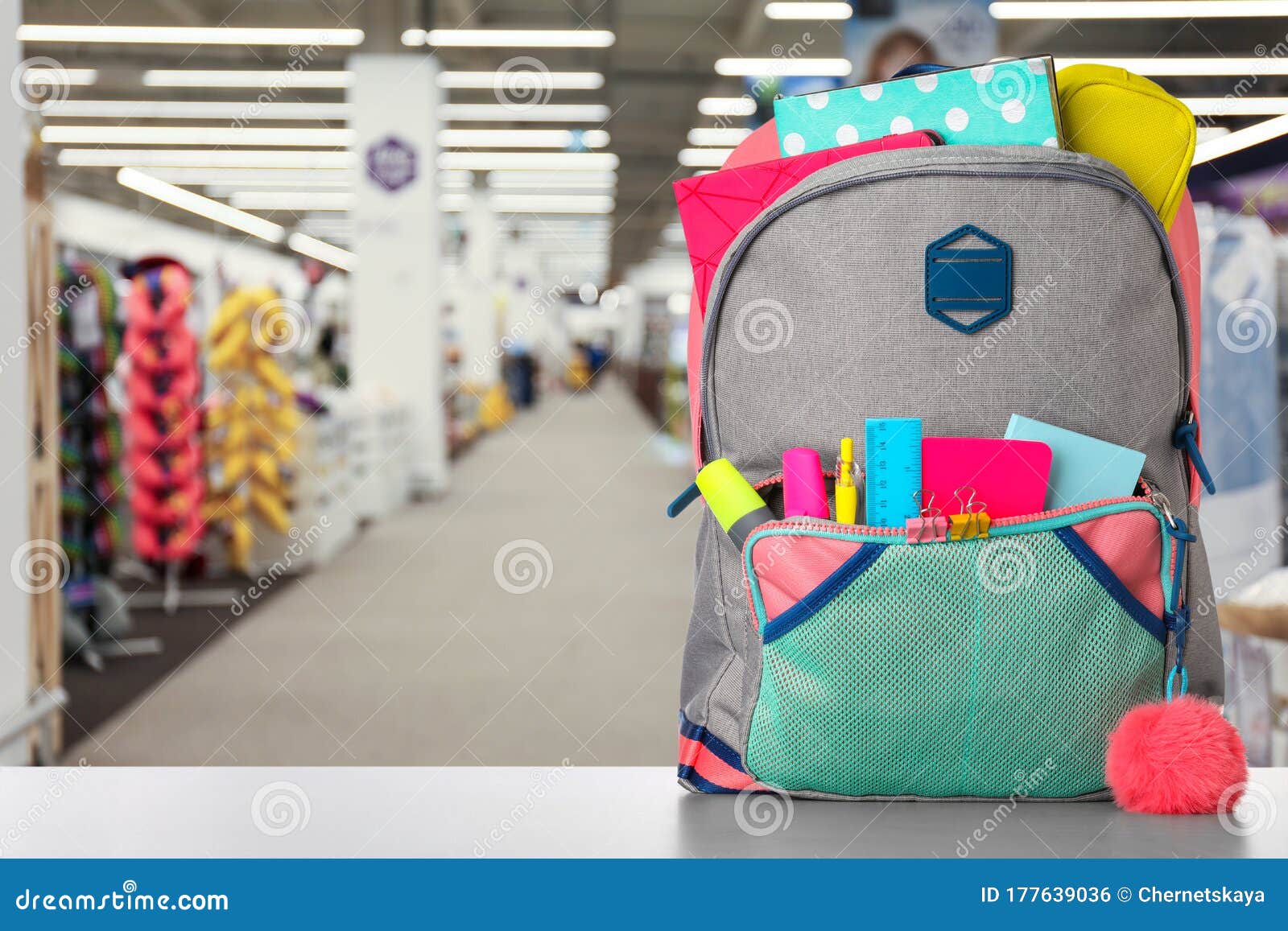 Backpack with School Stationery on Table in Shopping Mall. Space for