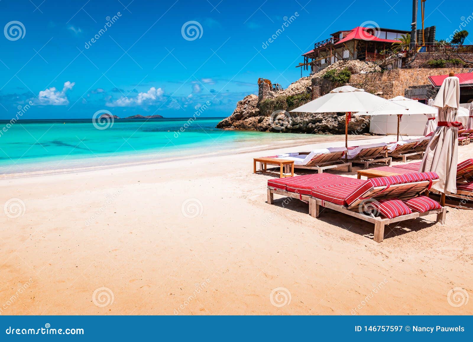 luxury beach chairs and umbrella on exotic beach in st barths, caribbean island.