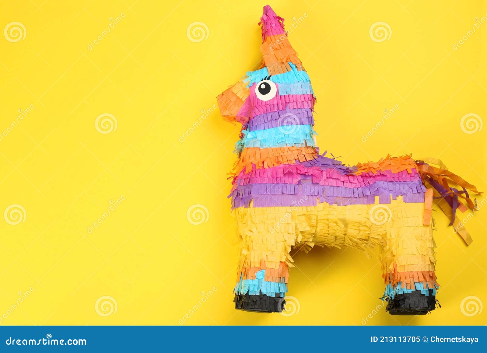 bright donkey pinata on yellow background, top view. space for text