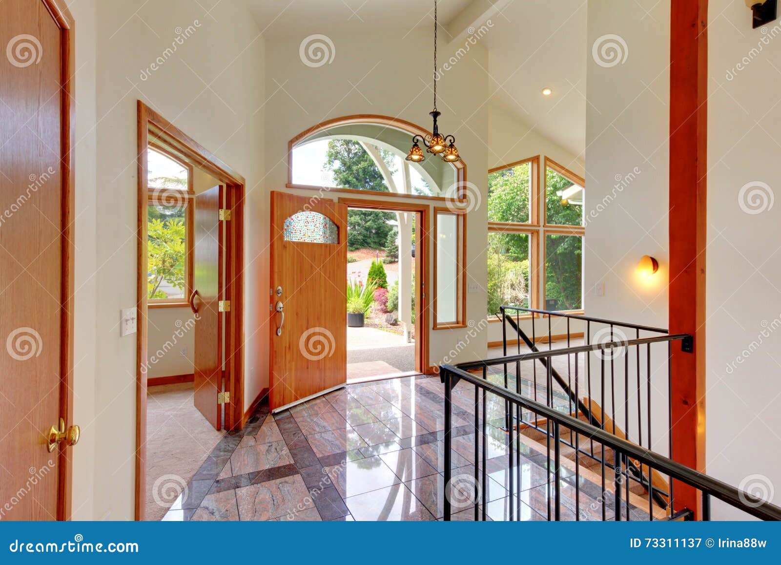 Bright Entry Way With Tile Floor And Staircase With Metal