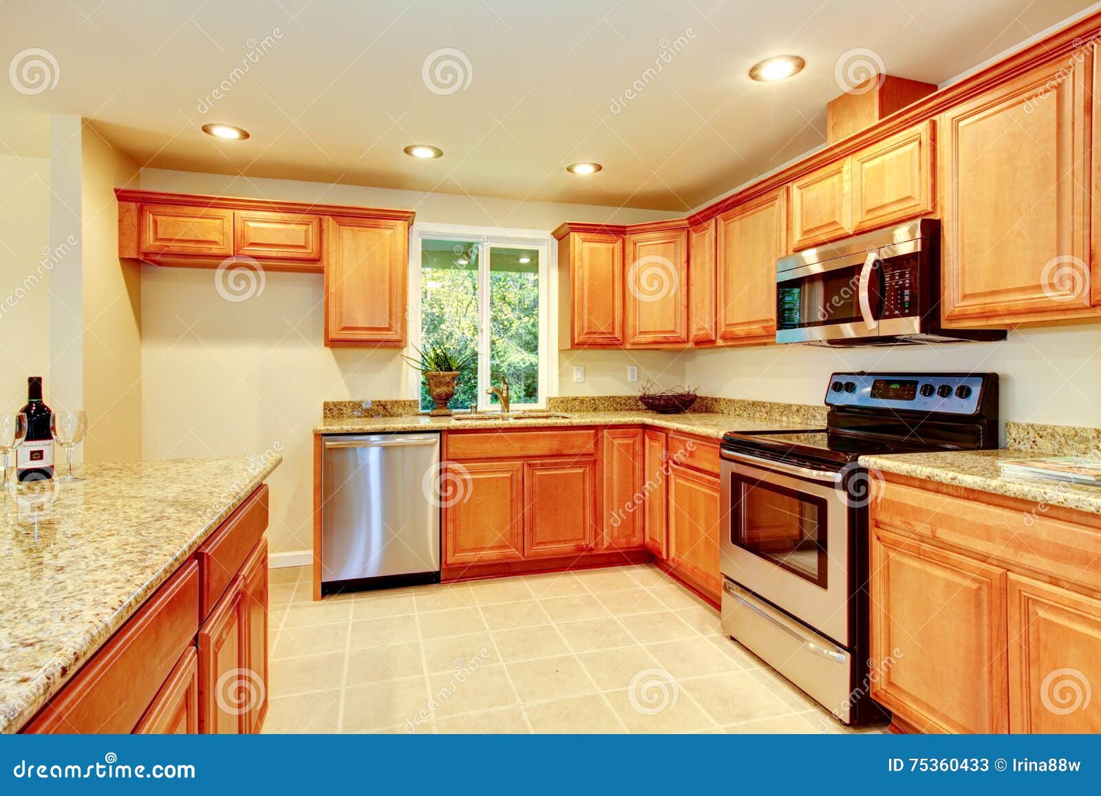 Bright Kitchen Room With Light Brown Cabinets And Steel Appliances