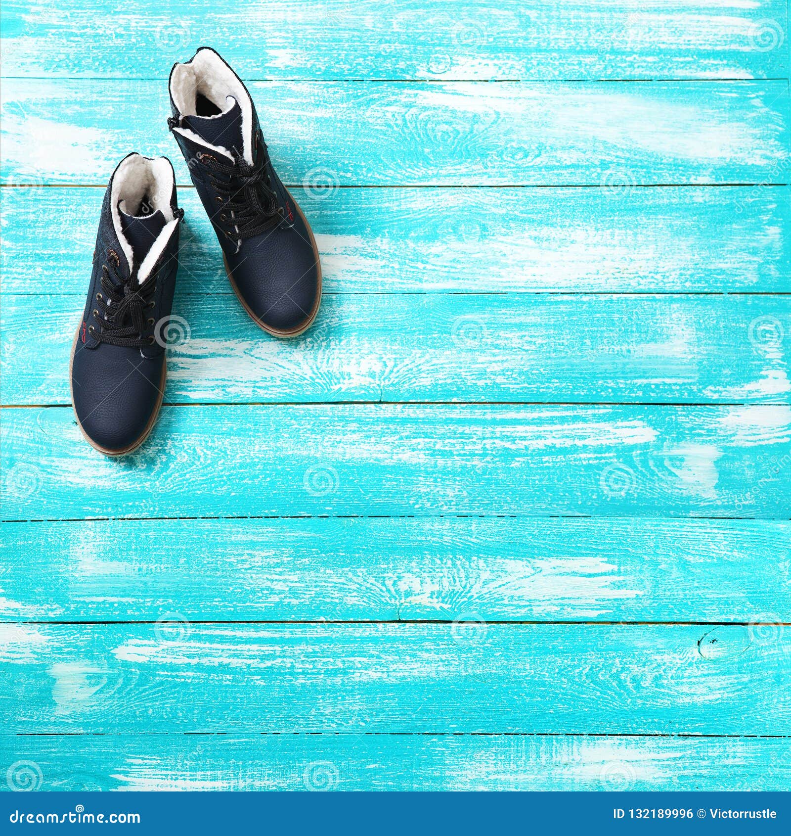 Bright Leather Winter Boots on Blue Wooden Background. Top View. Stock ...