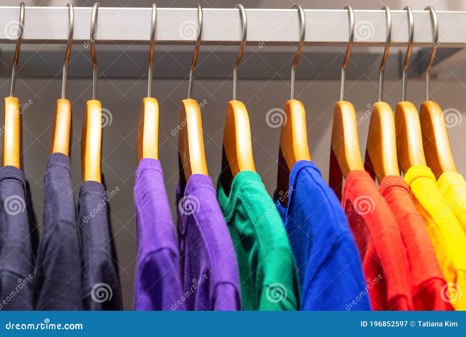 Bright Multicolored T-shirts Hang on Wooden Hangers in the Store Stock ...