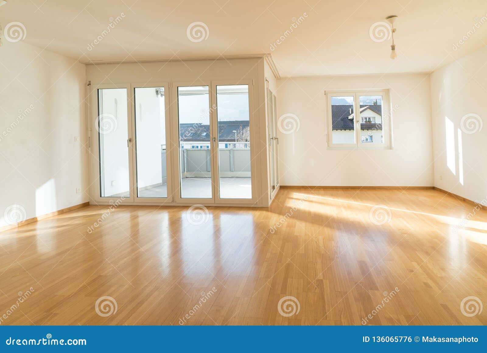 bright new living room in an empty apartment with french doors and parquet wooden floors