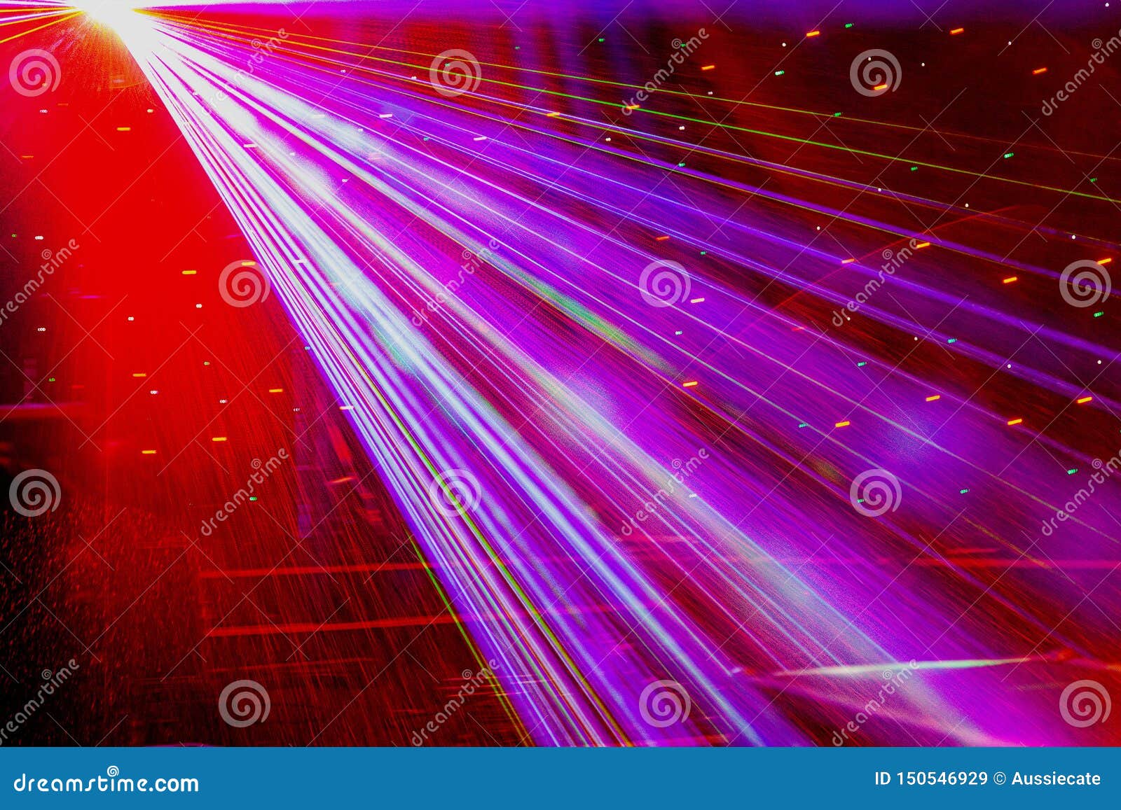 bright nightclub red laser lights cutting through smoke machine smoke making light and rainbow patterns on the dance floor.