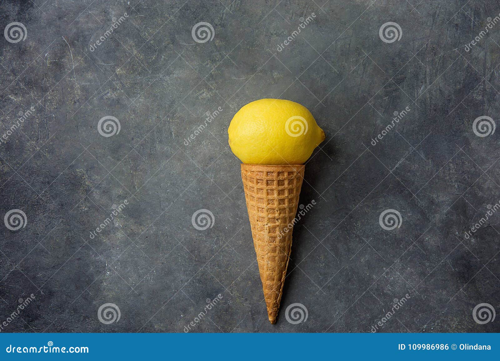 Bright Ripe Yellow Lemon in Waffle Ice Cream Cone on Dark Concrete Stone Background. Summer Fruits Dessert Freshness Vitamins Concept. Branding Image for Artisanal Food Products
