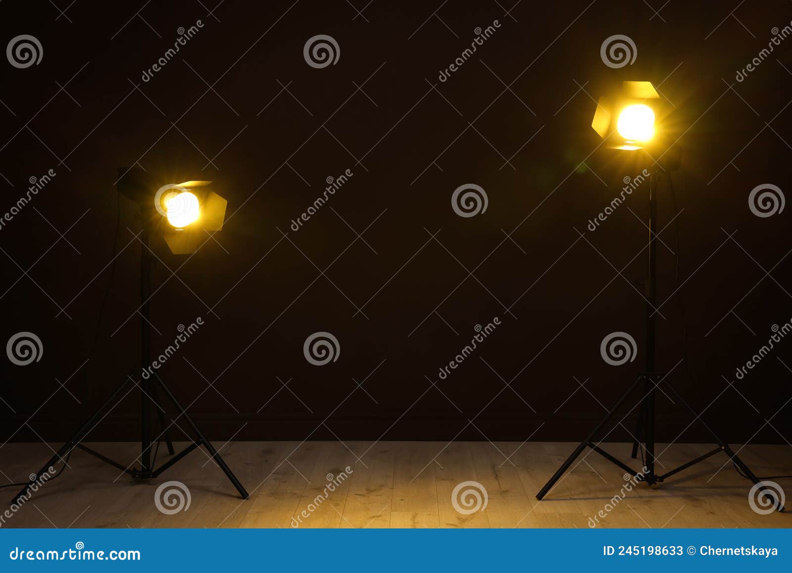 Bright Spotlights Near Wall in Dark Room, Space for Text Stock Image